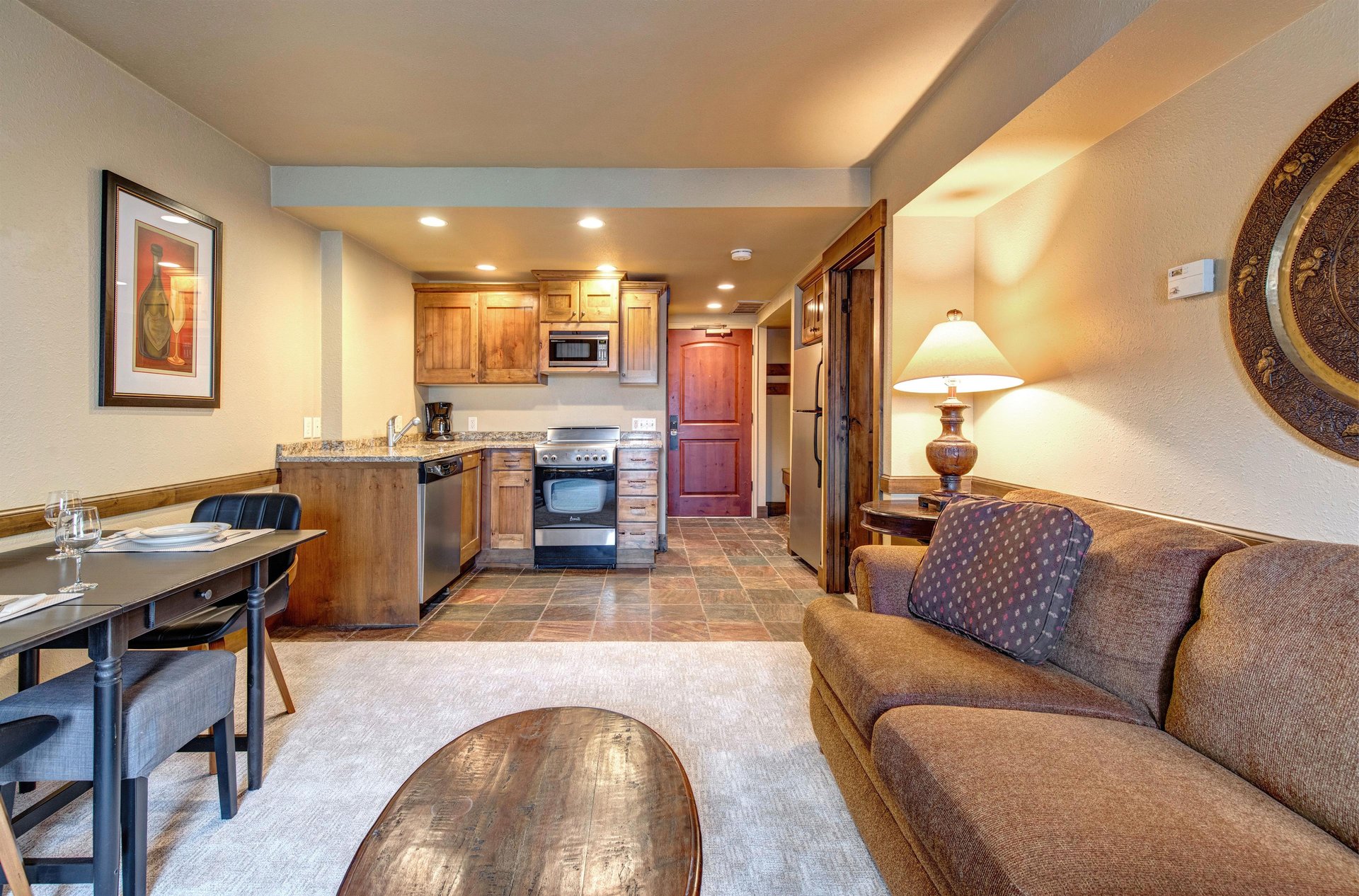 Your cozy openconcept space combines a fully equipped kitchen with warm wood cabinets and a stylish dining area.