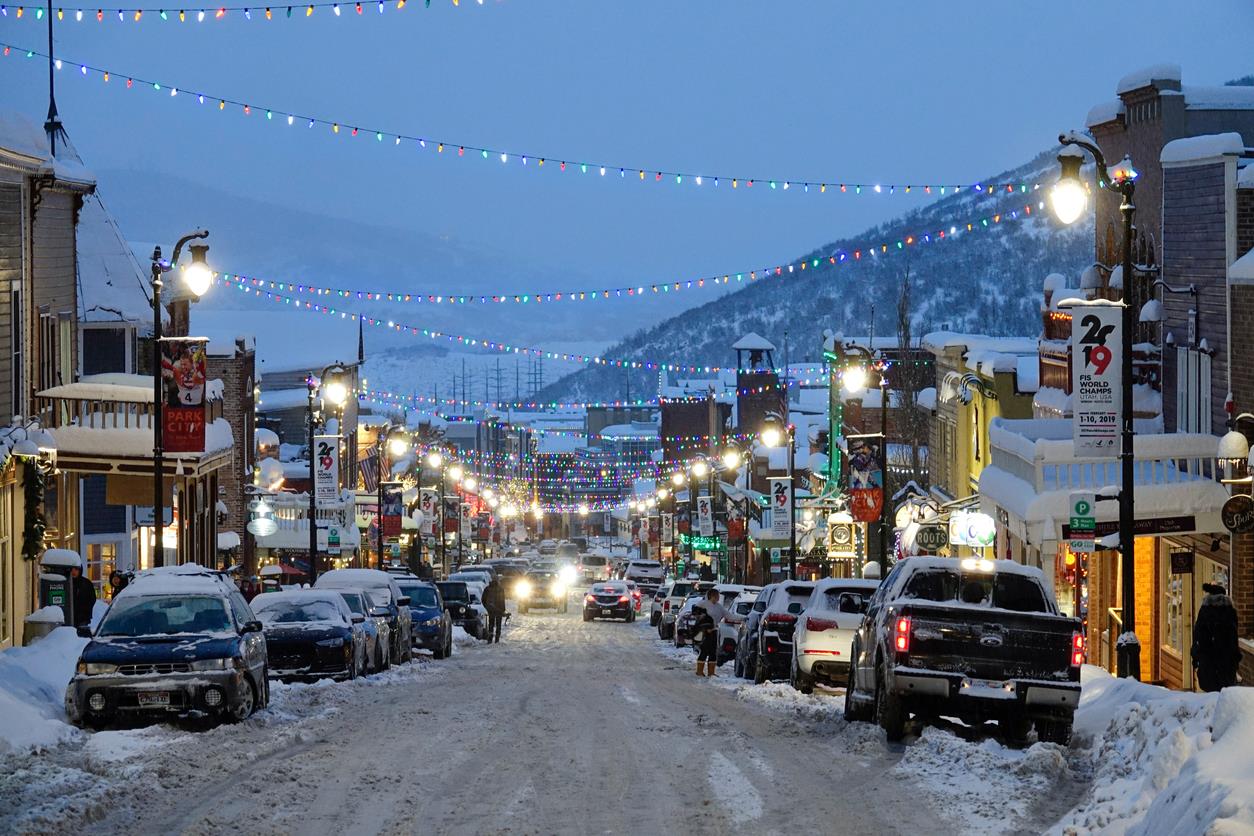 Main Street with snow on the ground and holiday lights strung across the street.