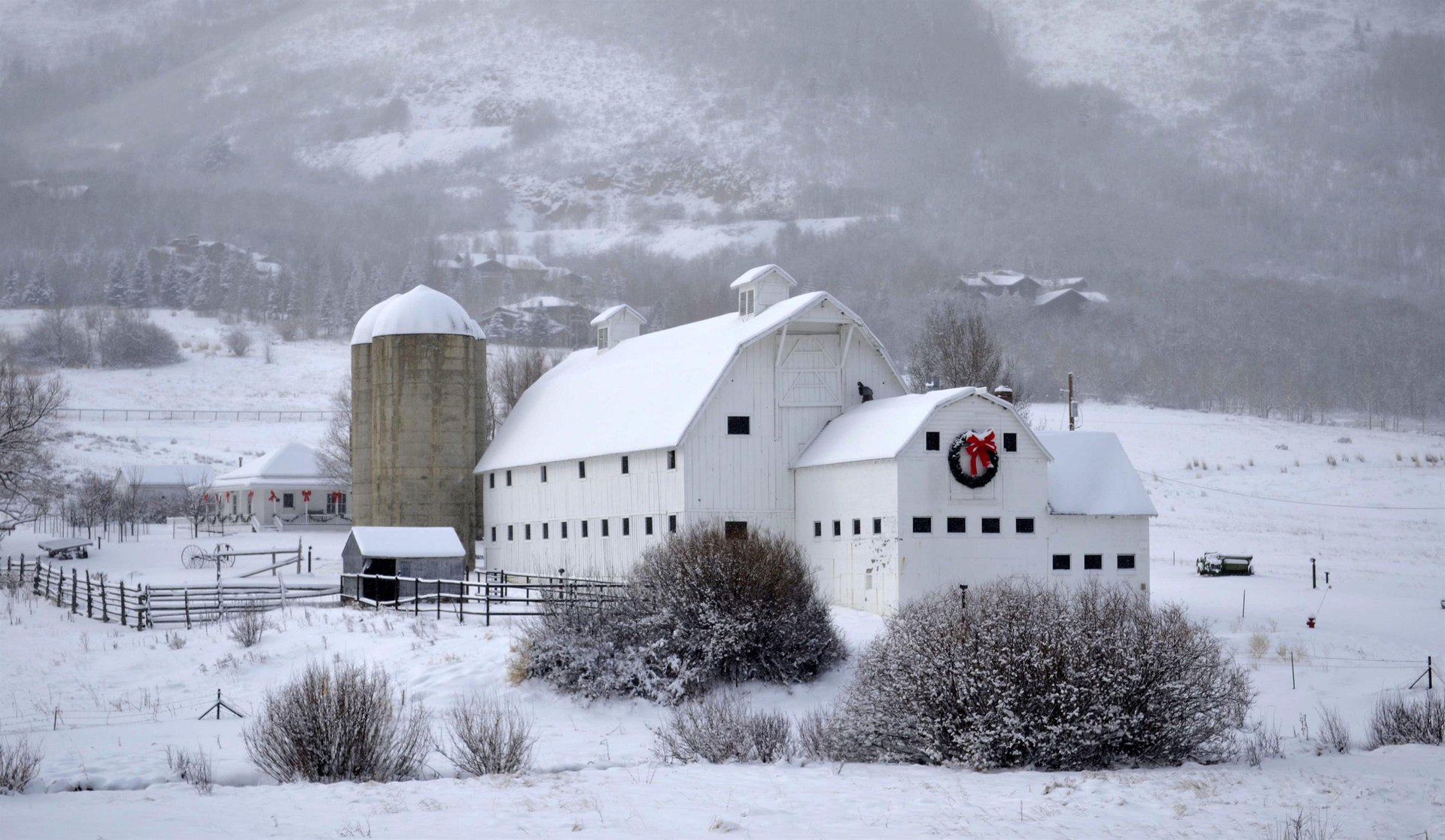 Historic McPolin barn in the winter with a huge holiday wreath on the front.