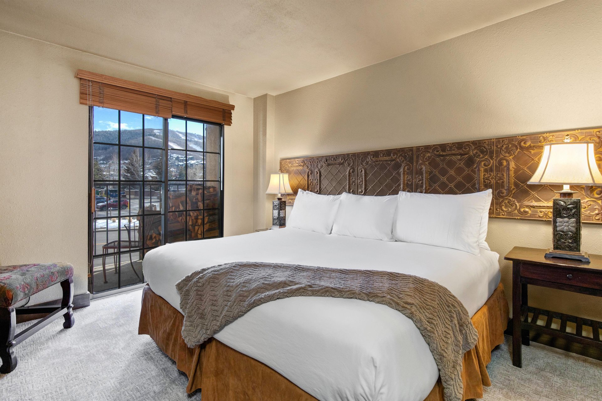 Sink into crisp white linens and enjoy the elegant carved headboard in your comfortable bedroom, featuring mountain views.