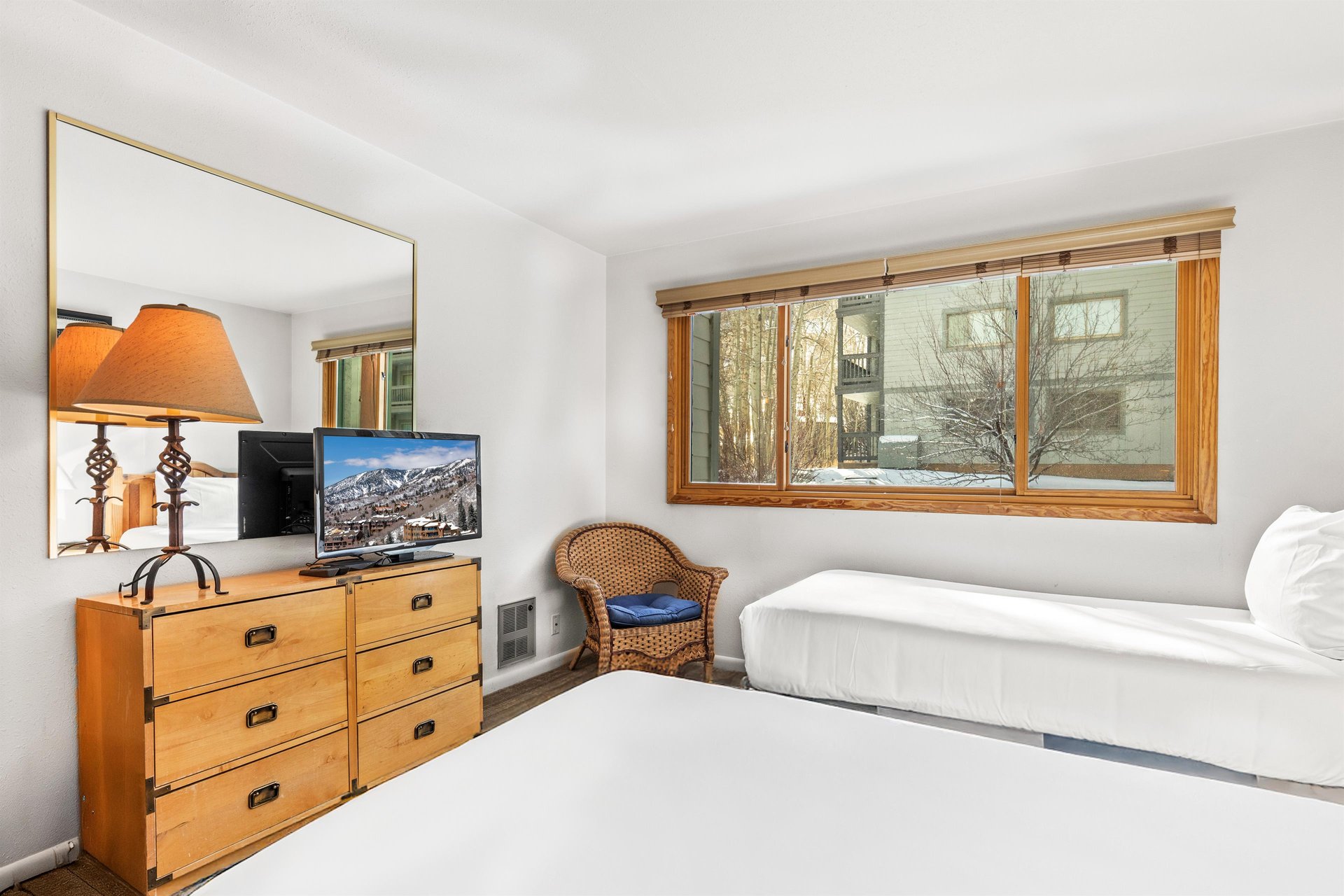 Relax in your comfortable bedroom with twin beds, entertainment center, and mountain views.