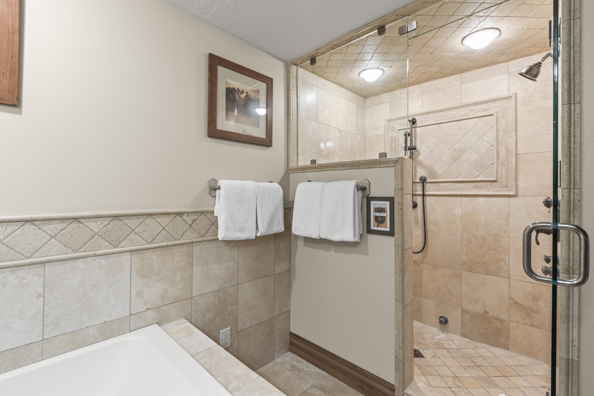 Unwind in your spalike bathroom featuring a spacious walkin shower with rainfall fixtures and elegant tile work.