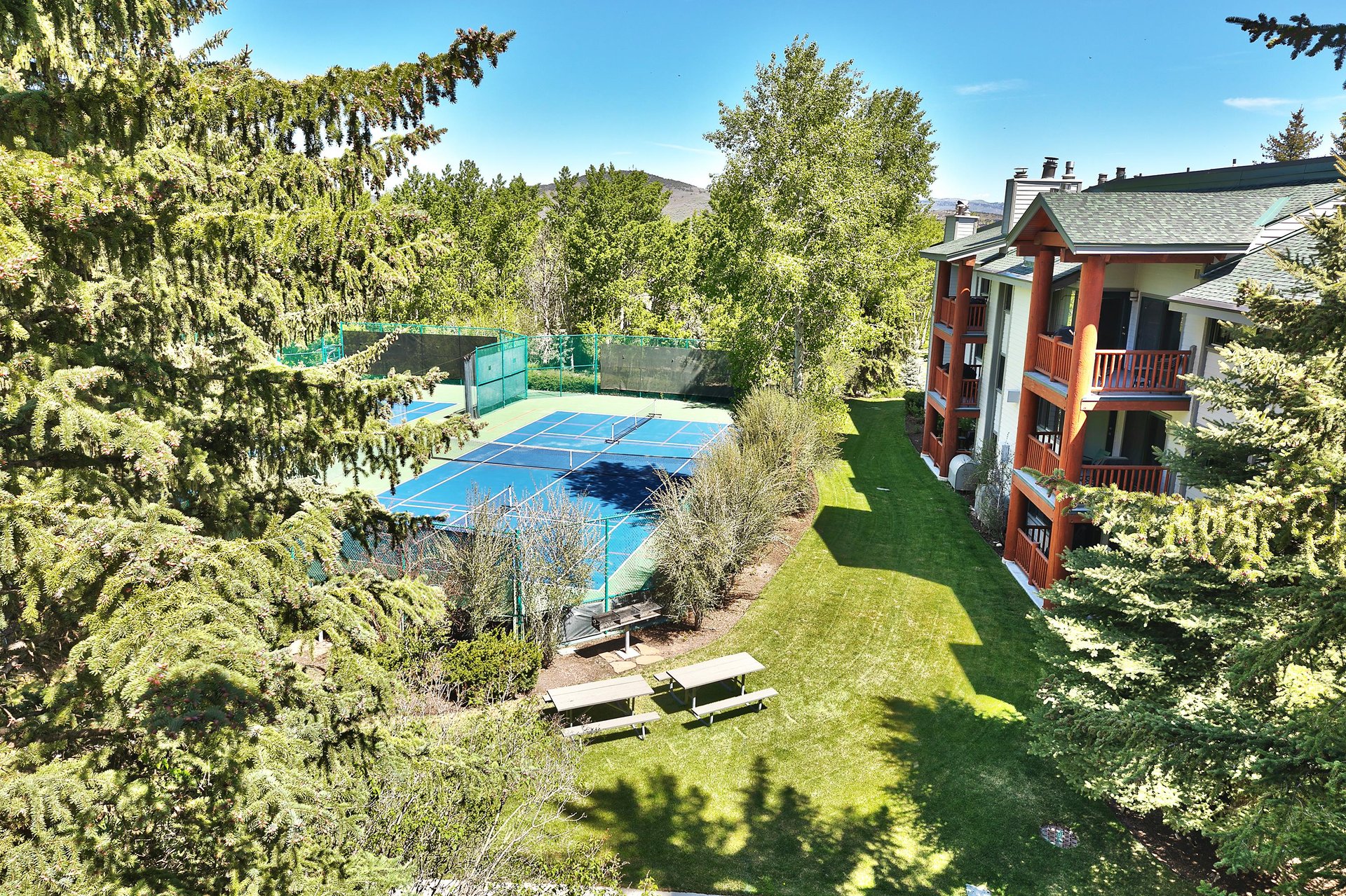 The private patio shows views of the tennis courts in the summer