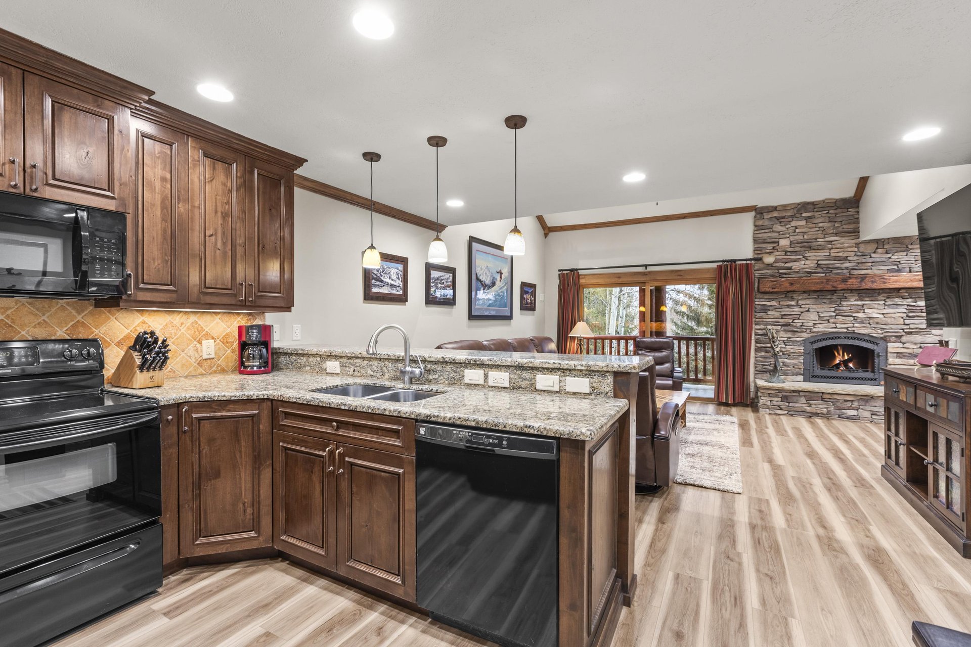 Your spacious kitchen features granite countertops, rich wood cabinets, and a cozy stone fireplace.