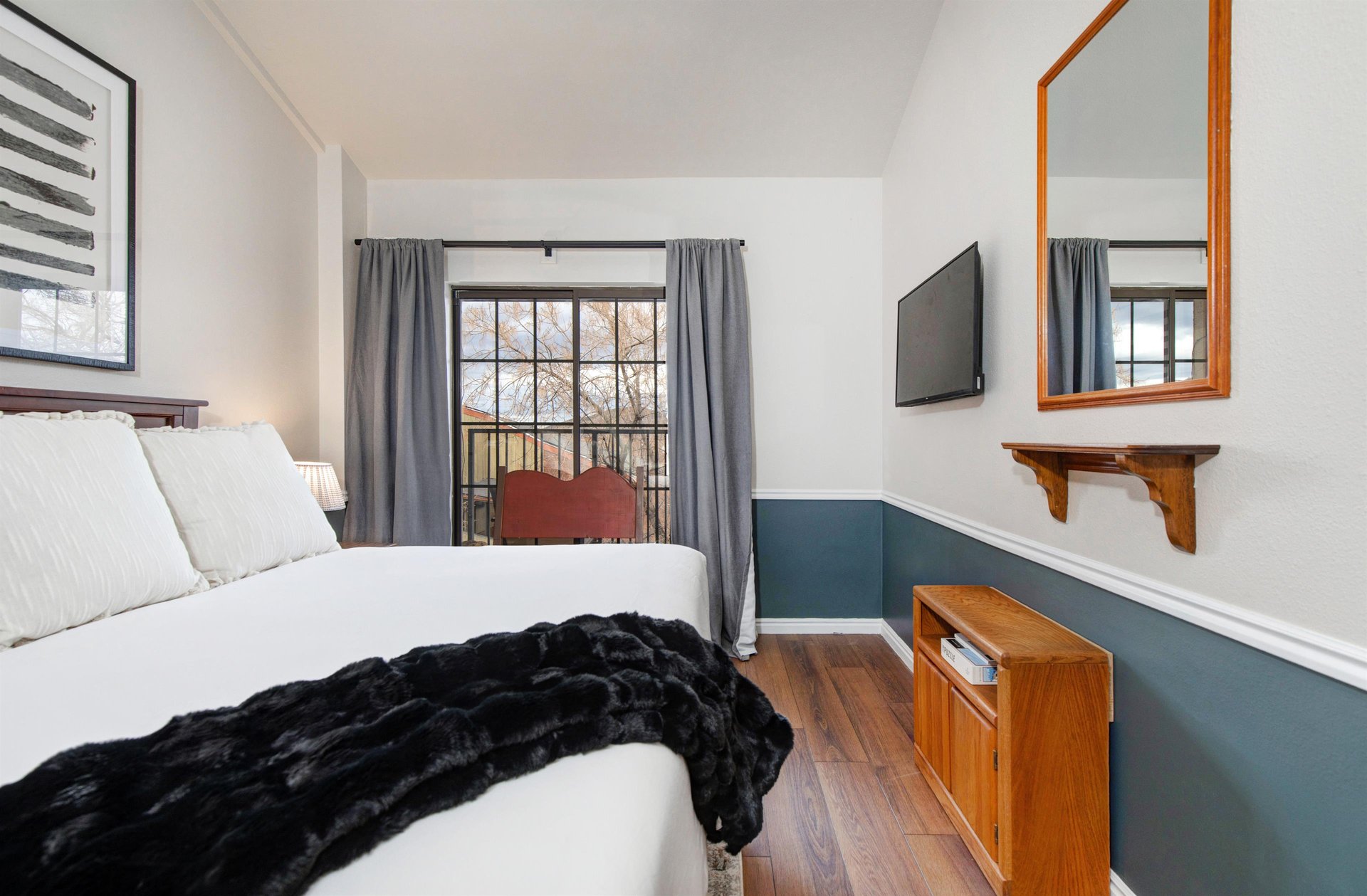 Unwind in your cozy bedroom with a peaceful balcony view through charming French doors.