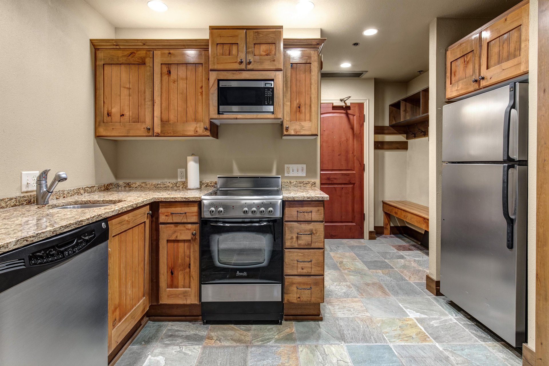 Cook your favorite meals in this fullyequipped kitchen featuring granite countertops and stainless steel appliances.