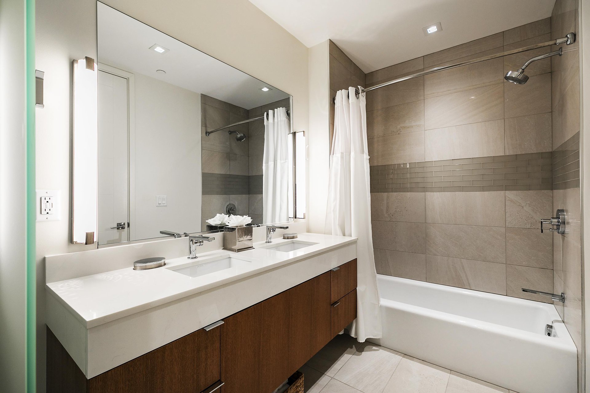 Full ensuite guest bathroom with dual vanity and step in showertub combo