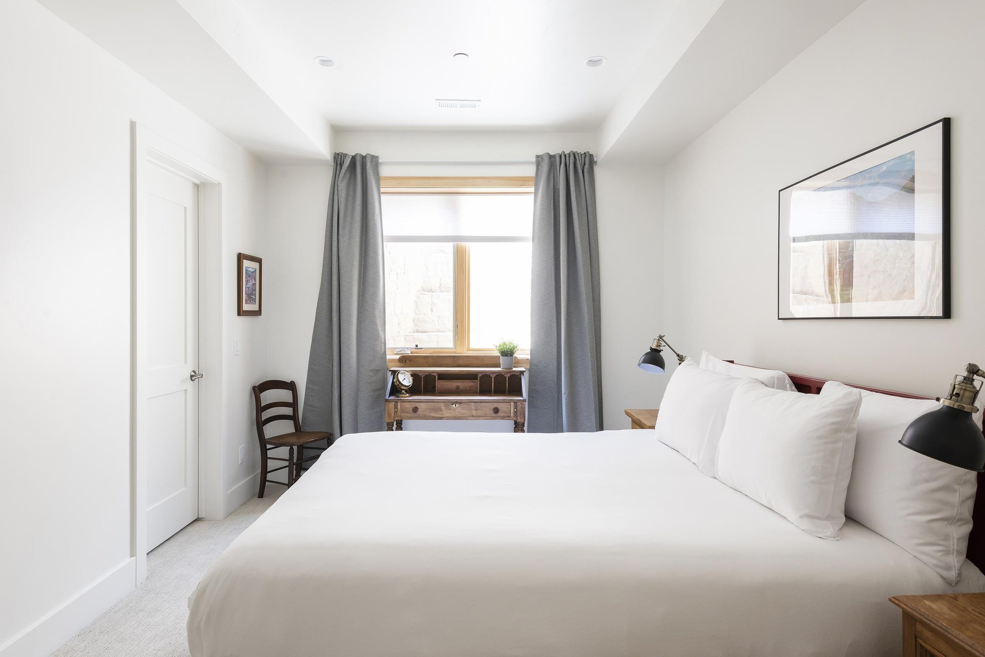 3rd guest bedroom with queen bed and window facing work or study desk