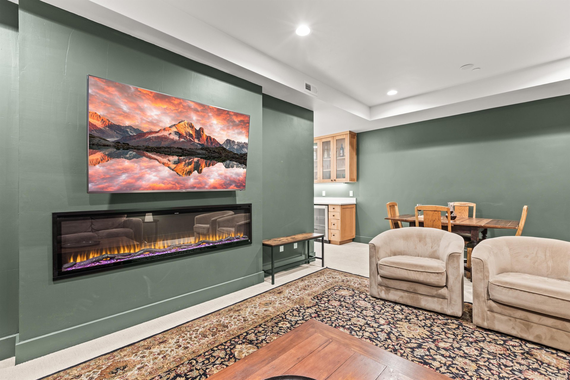 Cozy up in your elegant living space featuring a modern fireplace and large TV, perfect for relaxing evenings together.