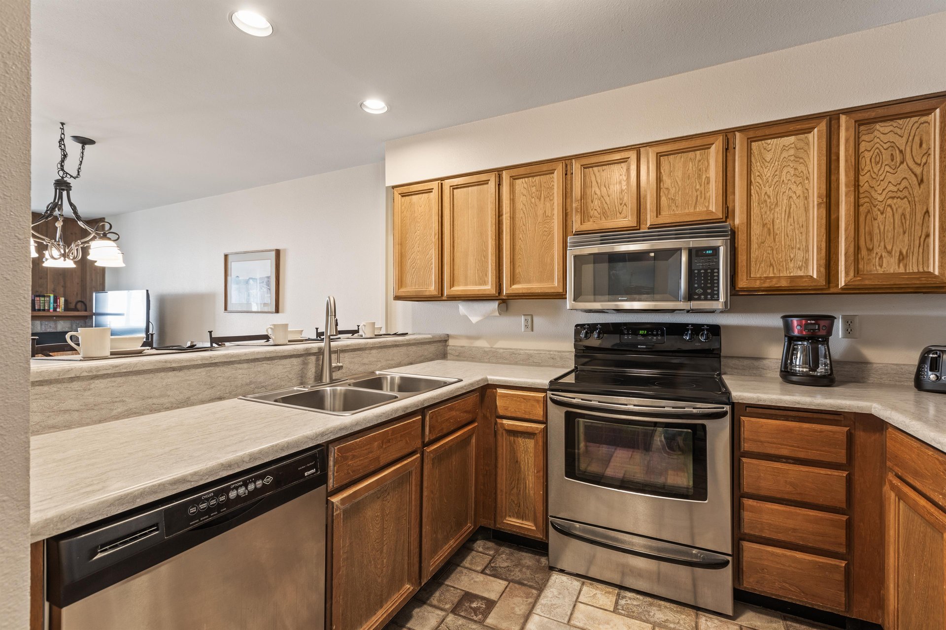 Snow Flower Condominium 147s open concept kitchen with stainless steel appliances.