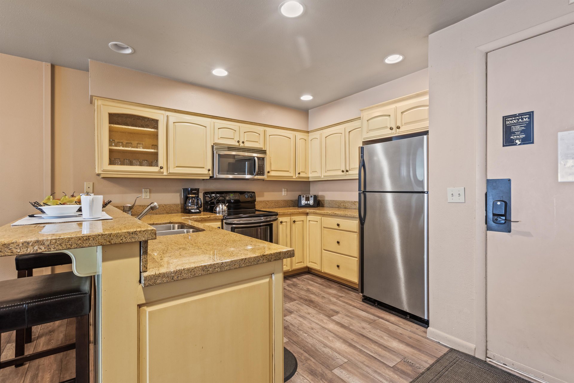 Premier Snow Flower Condominium 107s open concept kitchen with yellow cabinets and breakfast bar..