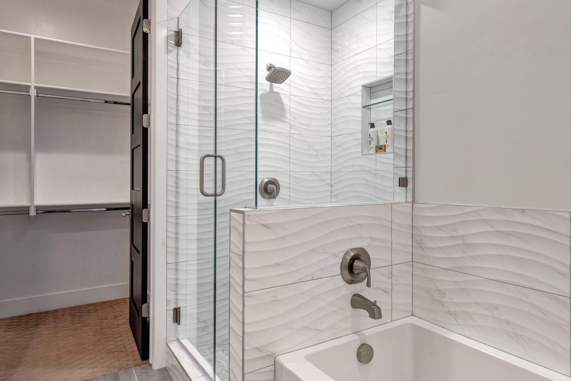 The en suite bathroom with wave like tile in the walkin shower and deep soaker tub.