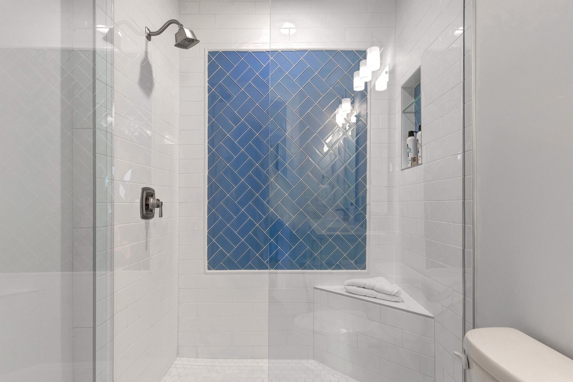 The shared bathroom with walkin shower and glass enclosure.
