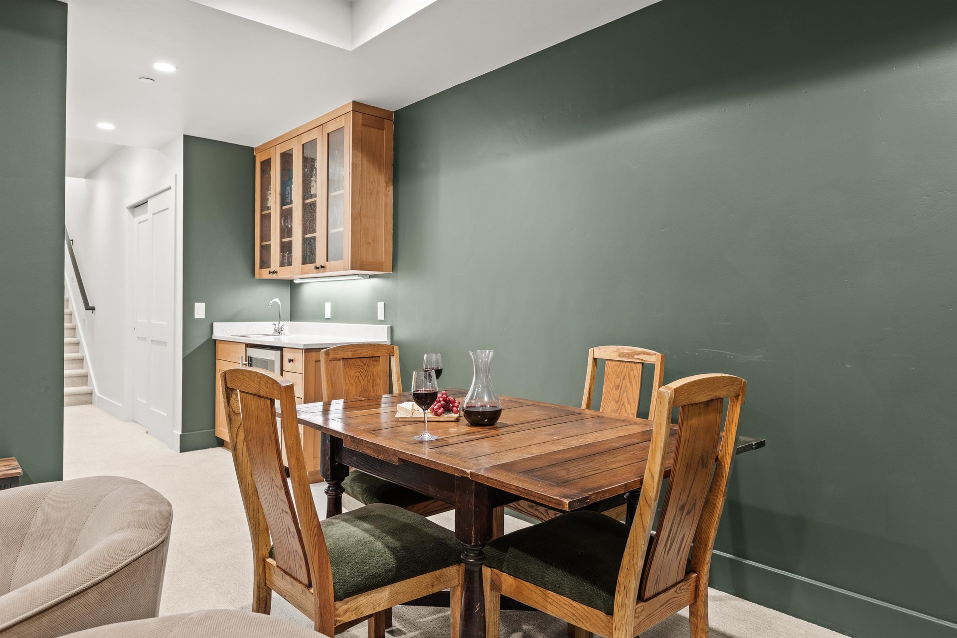 Your elegant dining space features warm wood furnishings against sophisticated sage walls.