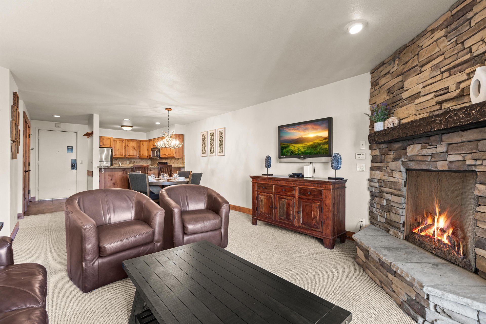 A spacious living room with comfortable leather seating and wallmounted TV.