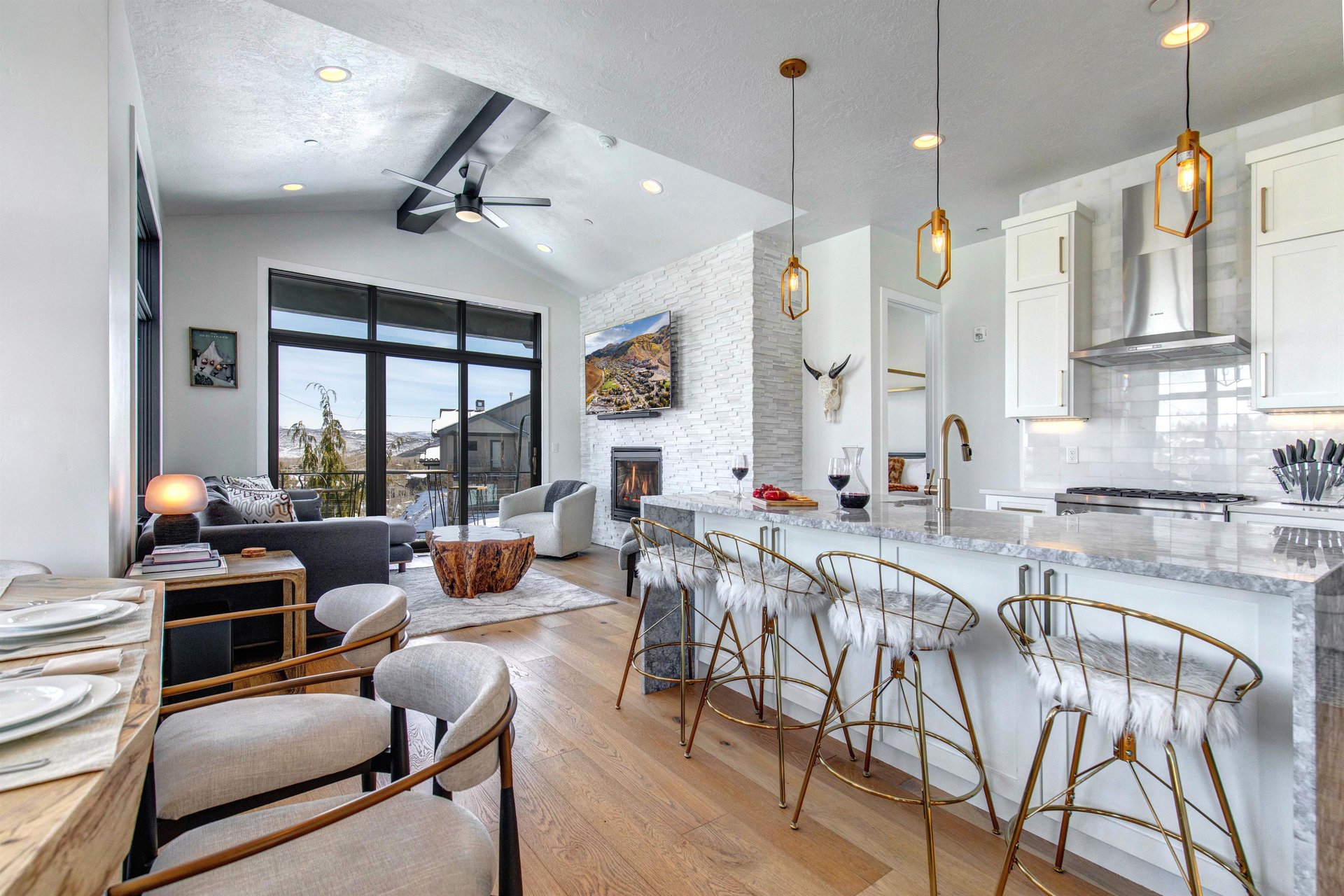 The open concept space offers a large kitchen island with seating for four guests, perfect for apres ski gatherings.