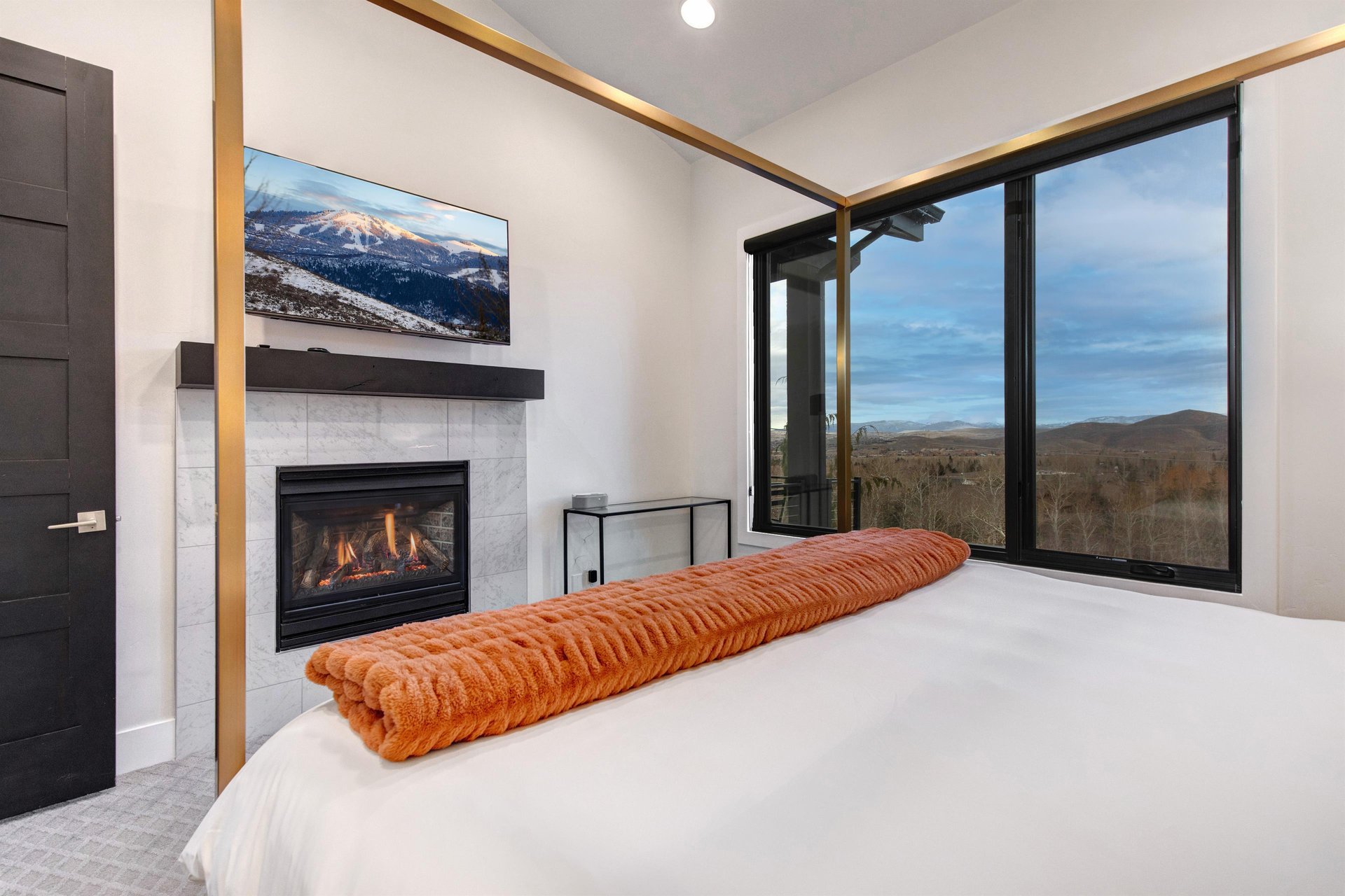 The main suite offers a gas burning fireplace, flatscreen TV and mountain views.