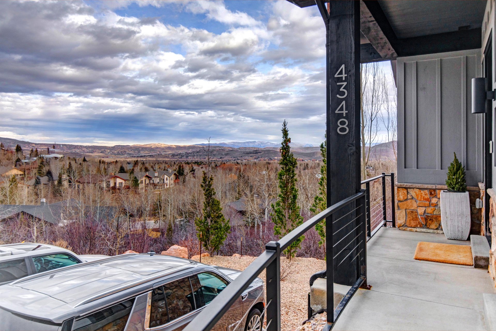 Modern mountain retreat entrance showcasing stunning valley views and convenient extra parking access.