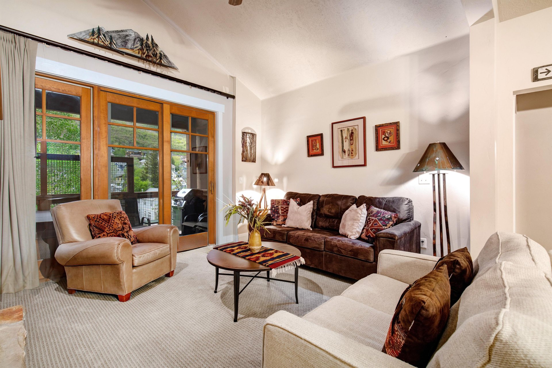 Sink into comfortable seating in your private living room, where natural light pours through sliding doors that open to your balcony. Warm leather, cozy armchairs, and thoughtful touches create your p