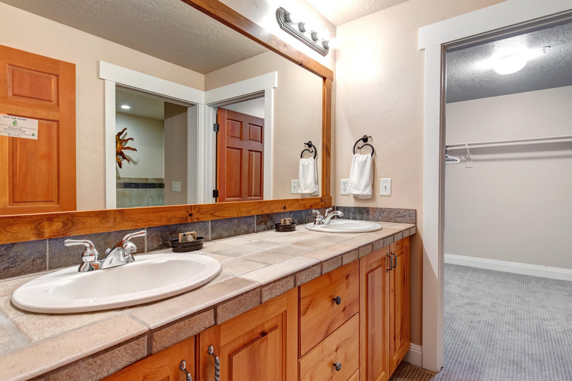 Youll love this bright, airy bathroom with double vanities, warm wood accents, and soft towels waiting for you—perfect for refreshing after a day of adventure.