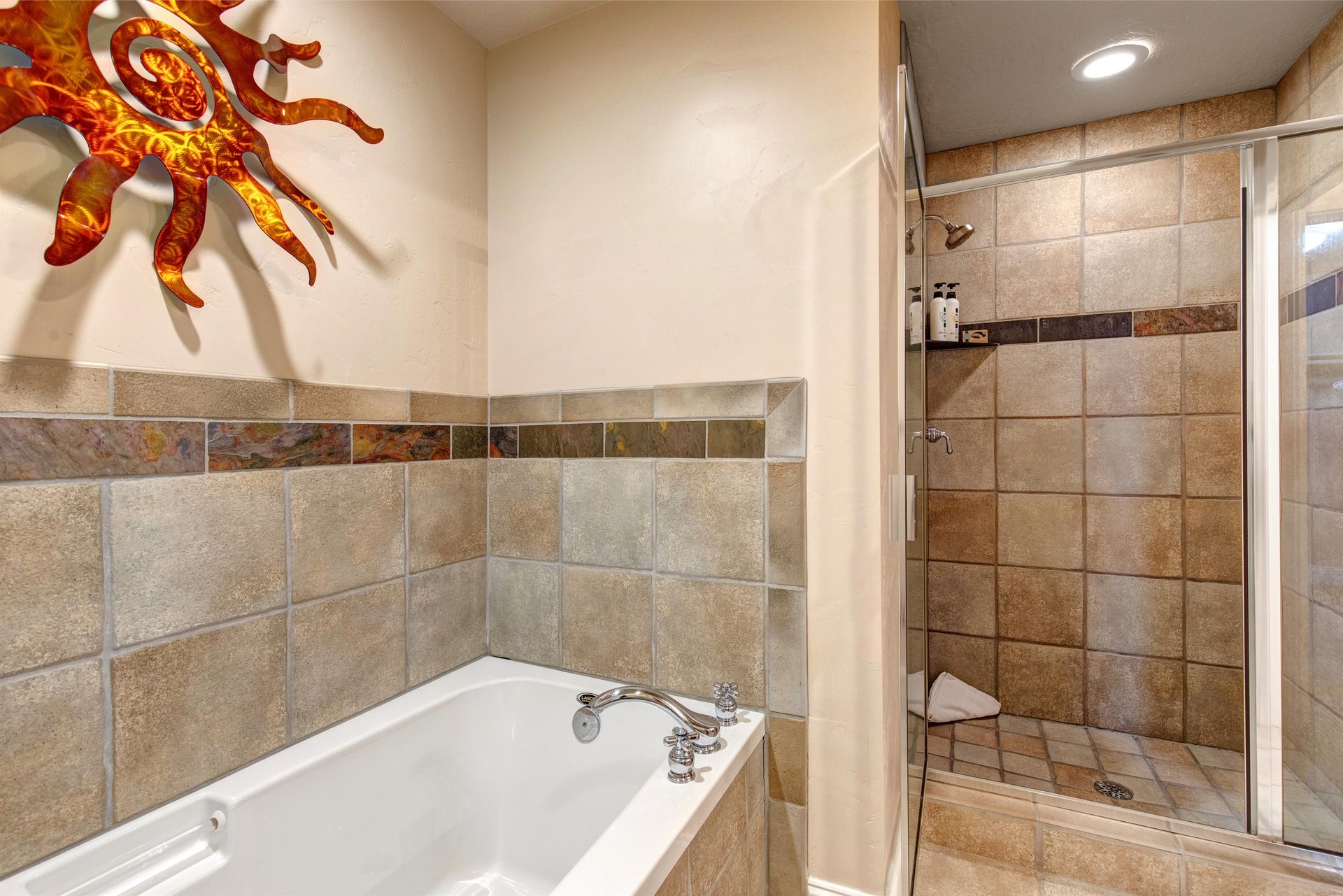 Soak in your deep tub or rinse off under the walkin shower—this earthytoned bathroom offers a serene retreat after mountain adventures, complete with playful sun décor overhead.