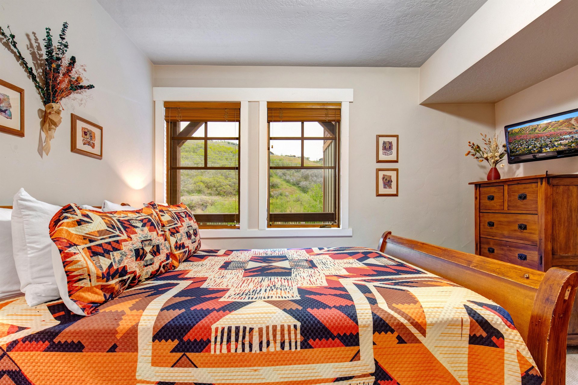 Sink into the plush quilted bed and let natural light pour through as you gaze at lush hillside views framing your restful retreat.