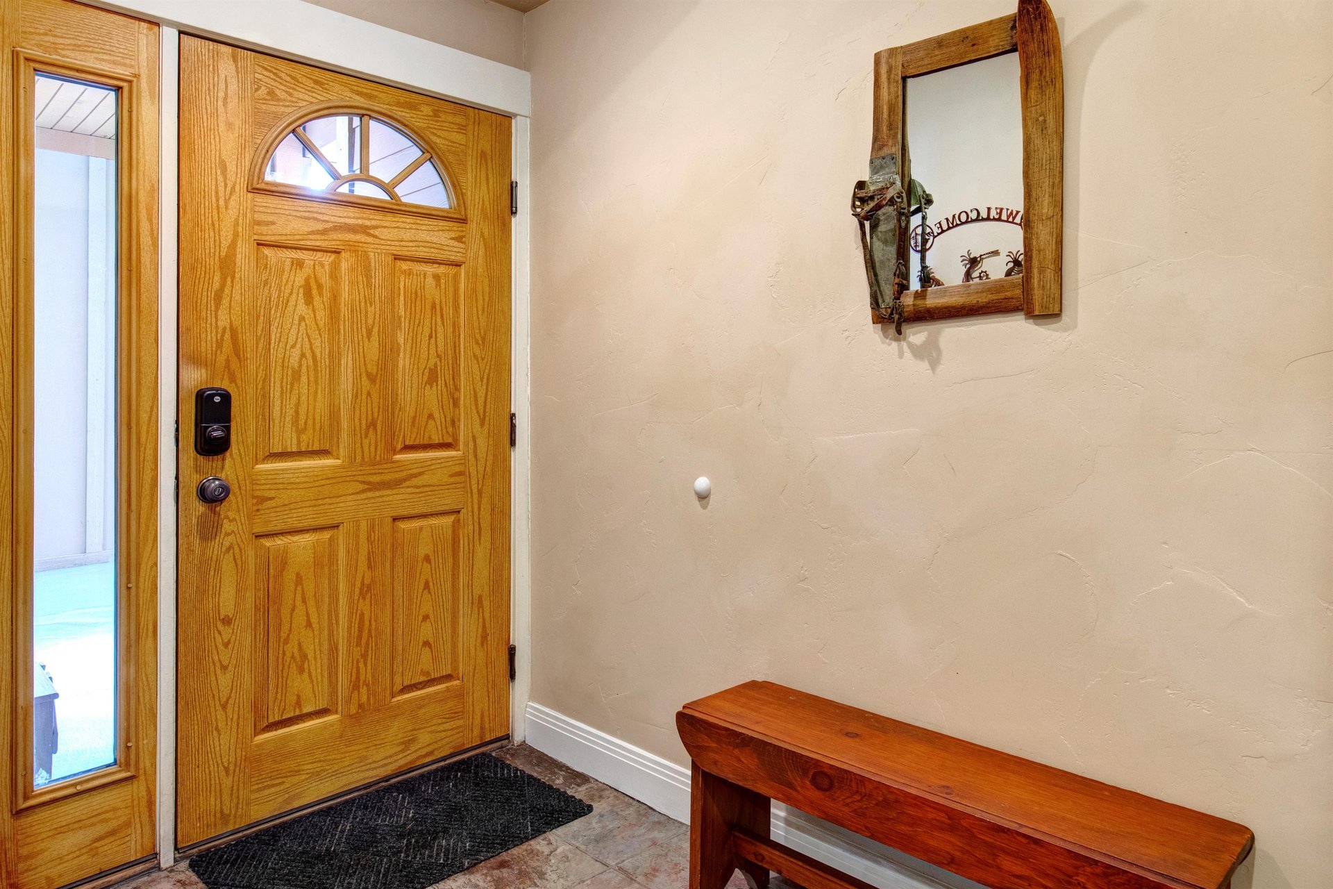 Step inside to a warm entryway with rustic charm. A welcoming bench offers you a spot to settle in, while thoughtful touches like a decorative mirror set the tone for your mountain retreat.