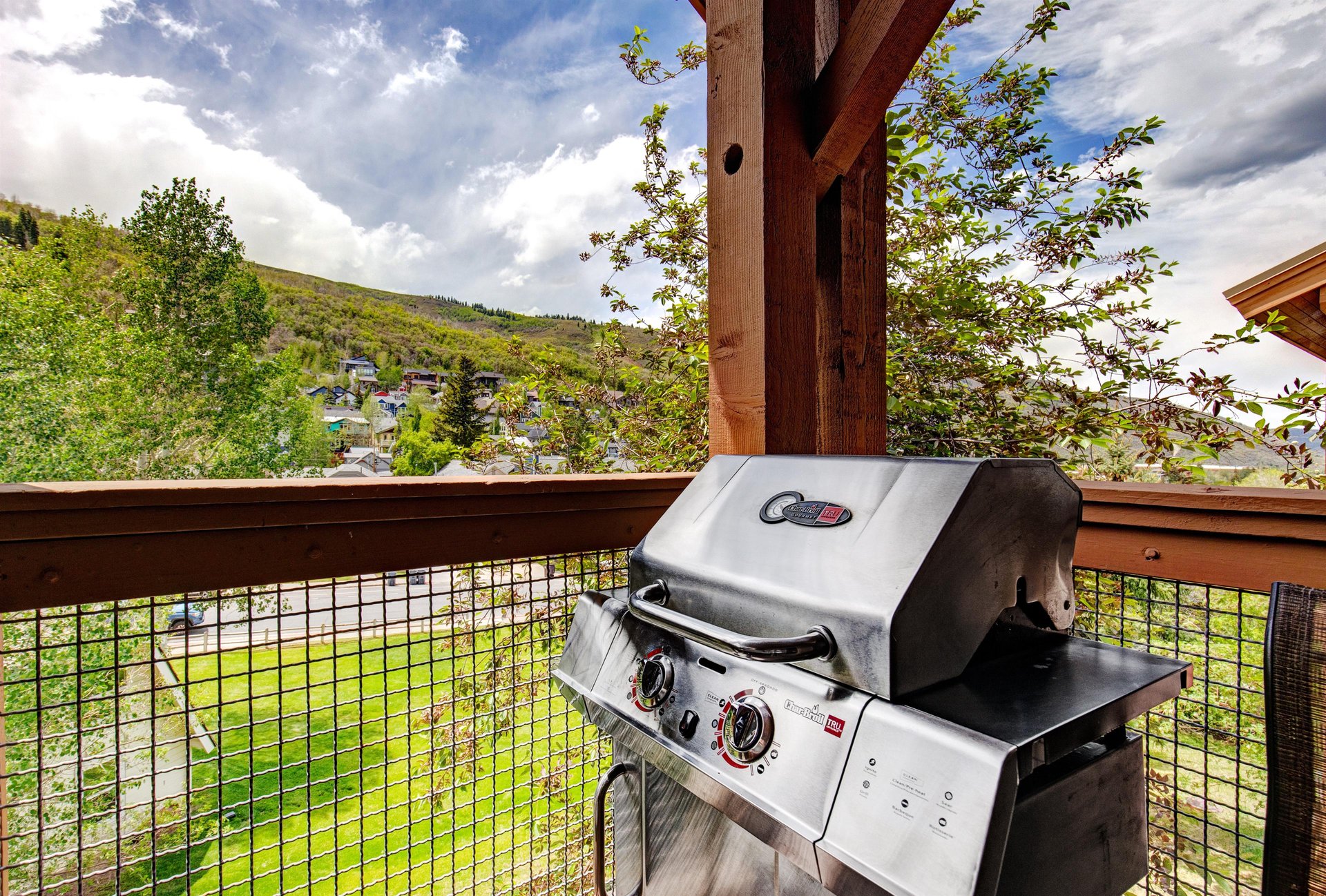 This gas grill on your private balcony invites you to savor meals outdoors while soaking in peaceful mountain and neighborhood views, perfect for grilling fresh dinners in the open air.