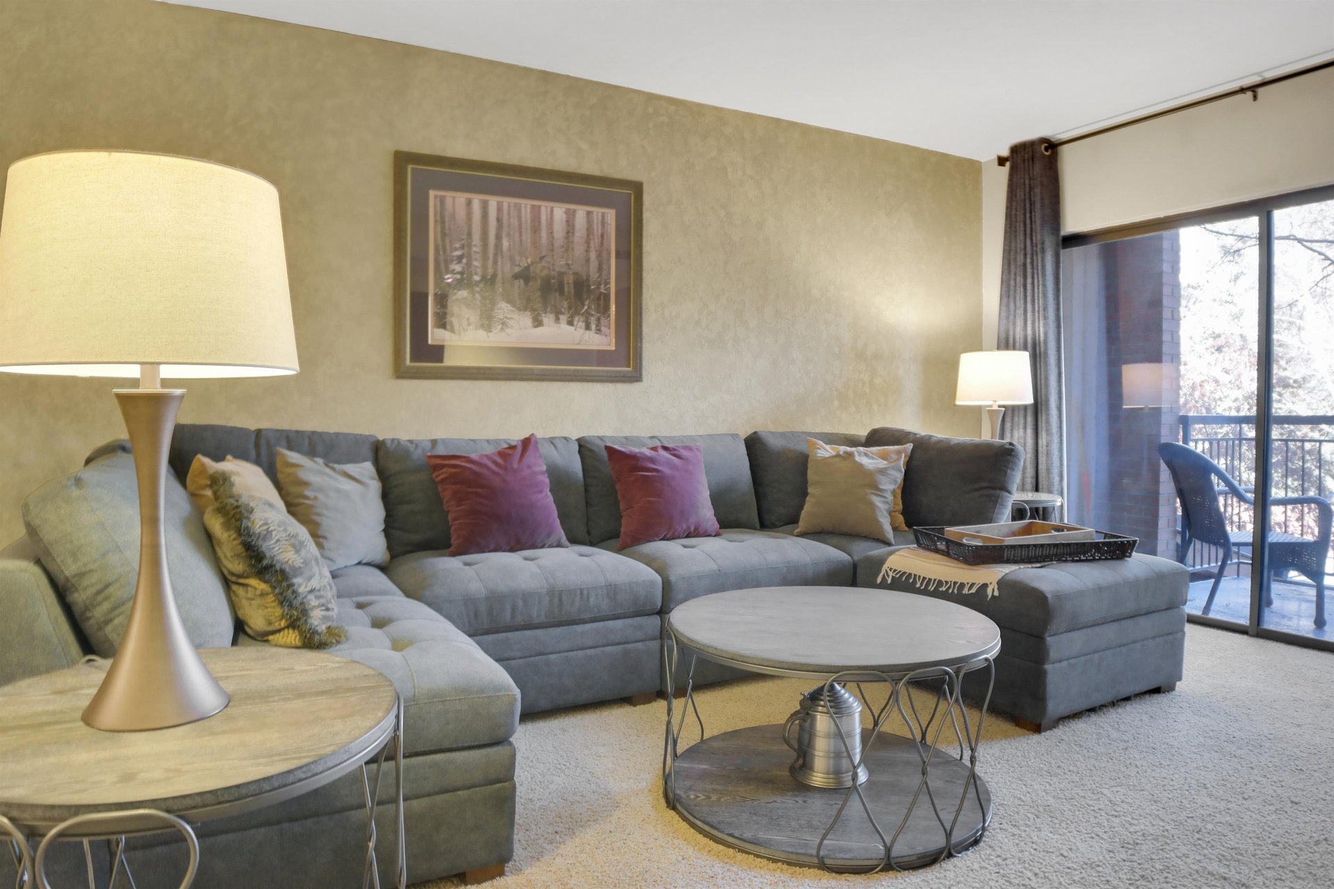 Park Station 122s living room has a grey upholstered sofa, throw pillows, modern round coffee table, and 2 lamps.Park Station 122s living room has a grey upholstered sofa, throw pillows, modern roun