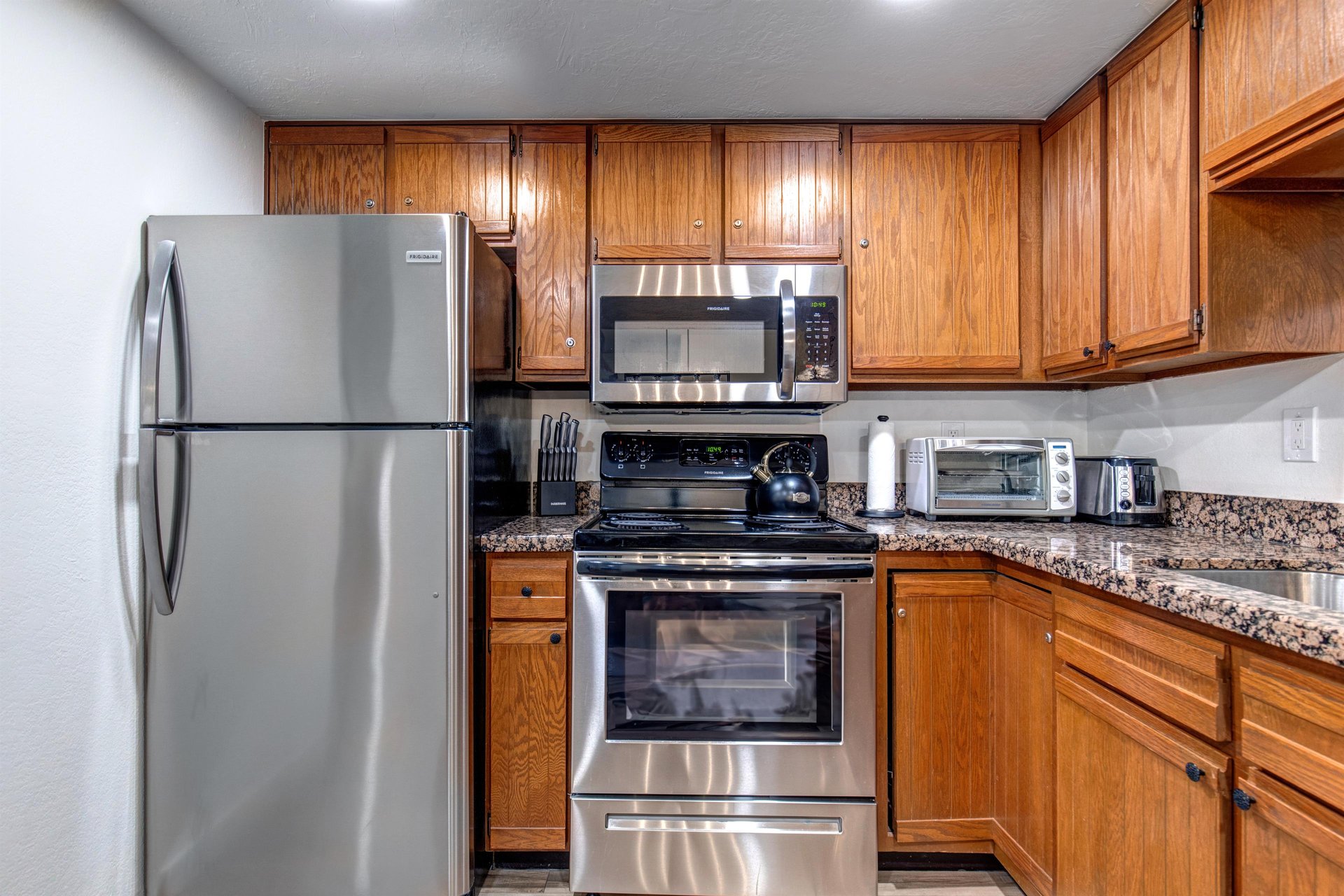 Park Station 133s kitchen has sparkling stainless steel appliances and a toaster over on top of the counter.