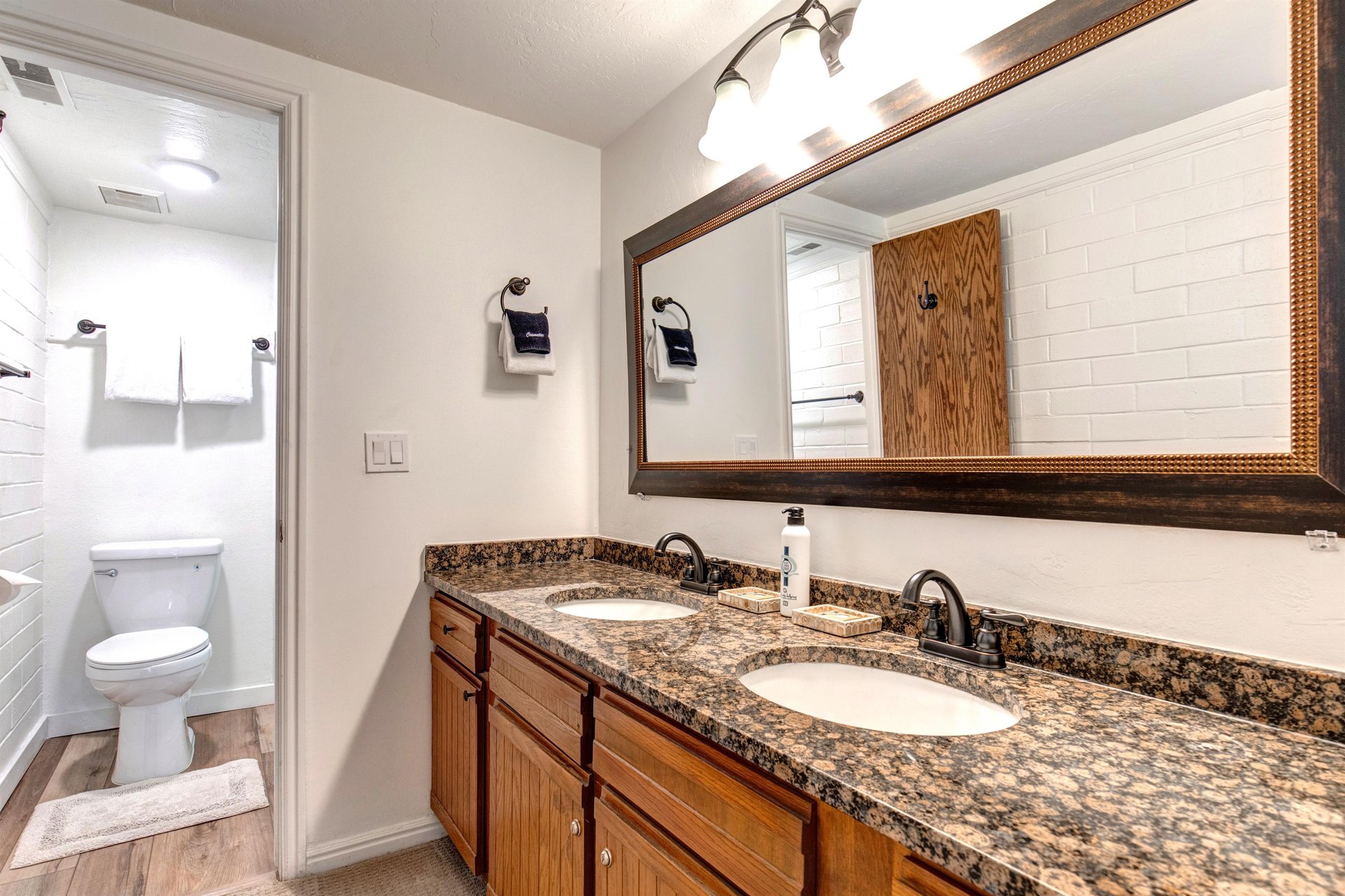 The main suite has an en suite bathroom with double sink vanity, large mirror, and granite counter tops.