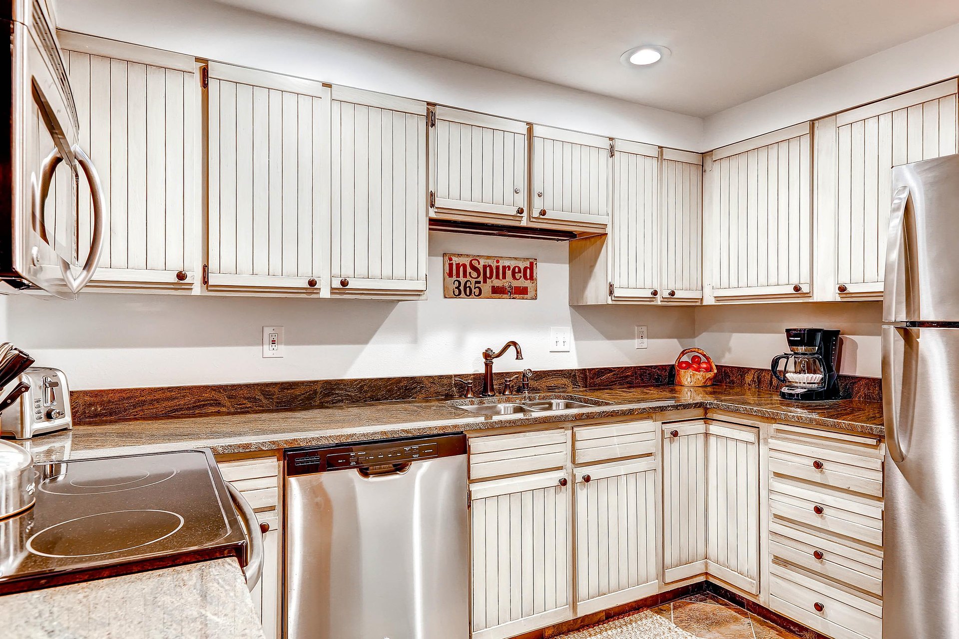 Park Station 134s kitchen with white cabinets, recessed lighting, and stainless steal appliances.