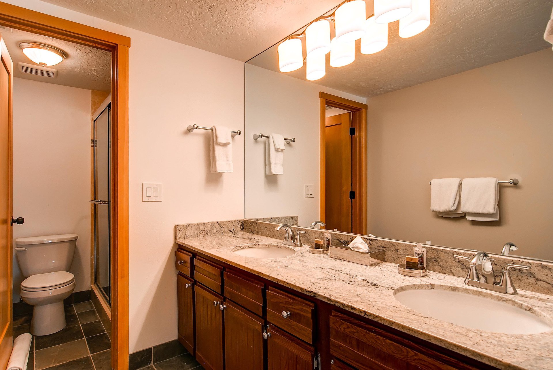 The en suite bathroom has a two sink vanity and a separate water closet.