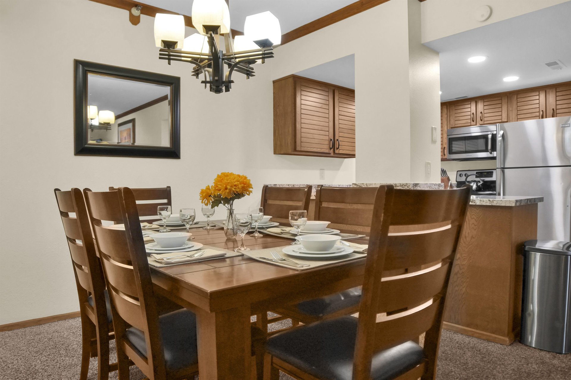 Park Station 214 has a dining area with seating for 6 on a wooden table and wood chairs with leather seats.