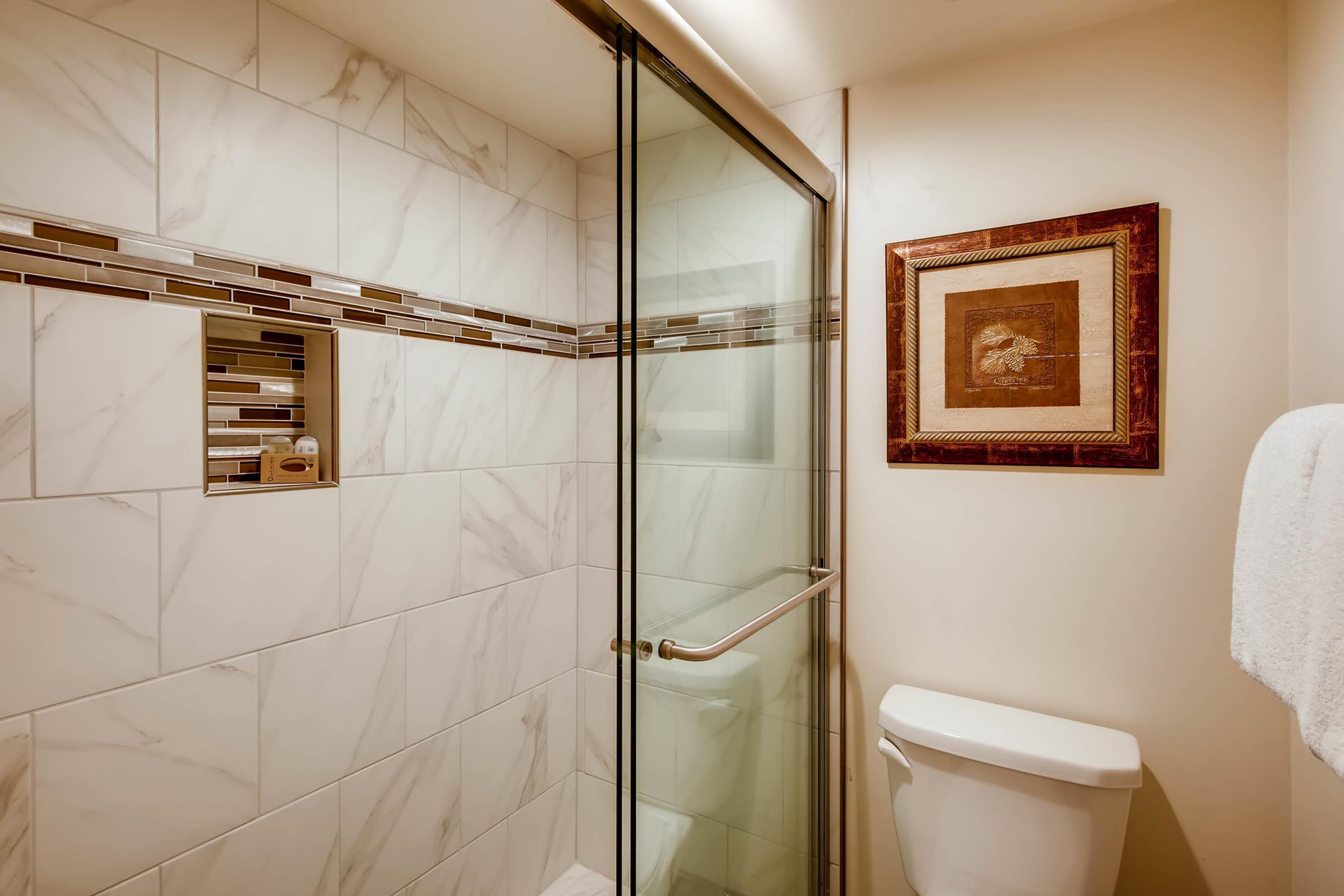 The en suite bathroom has a bathtub and shower combination with sliding glass doors.