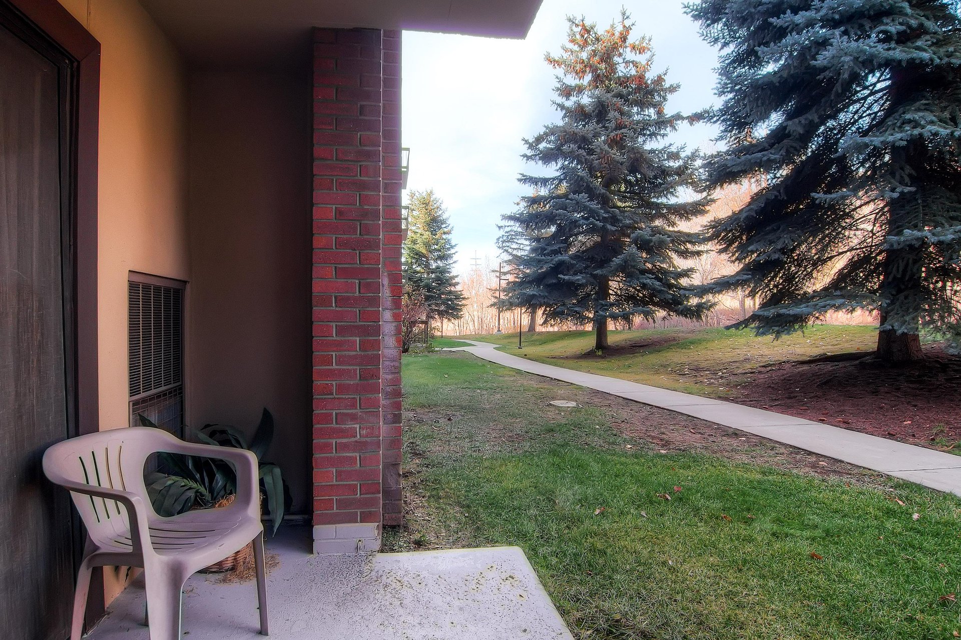 Park Station 121s private patio a chair and lovely trees beyond.