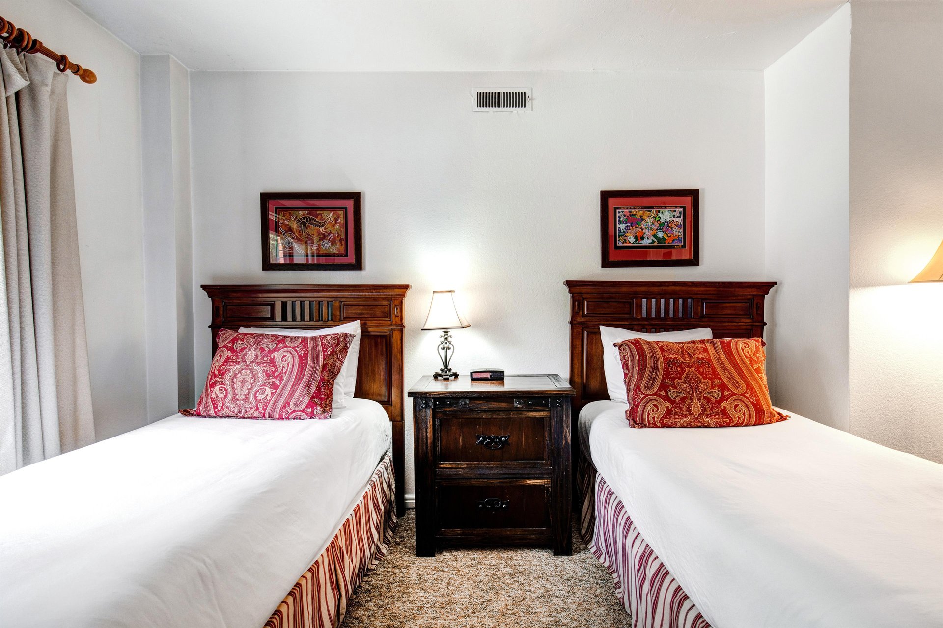 The second bedroom offer two twin beds with wooden furniture.