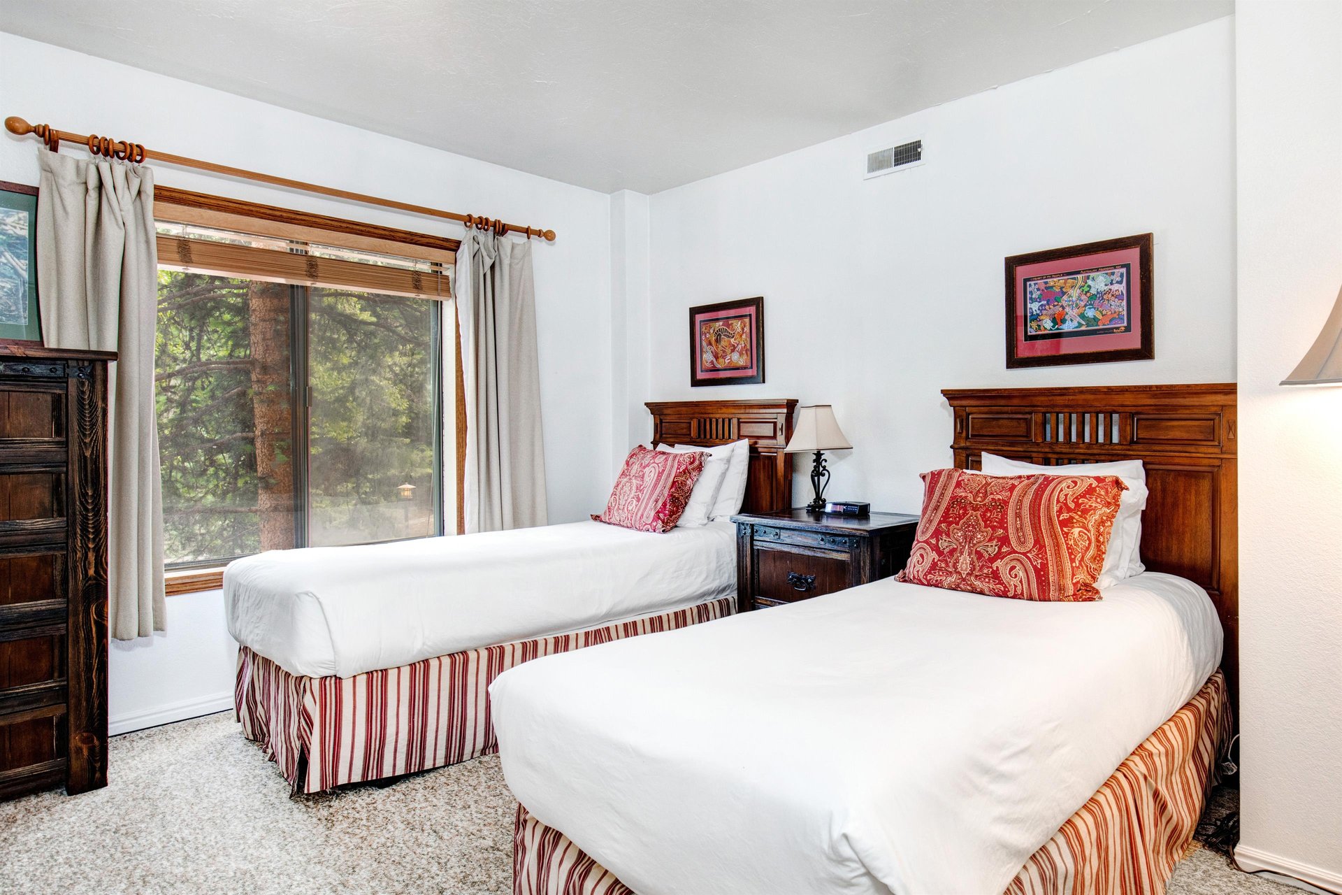 The second bedroom offer two twin beds with wooden furniture.
