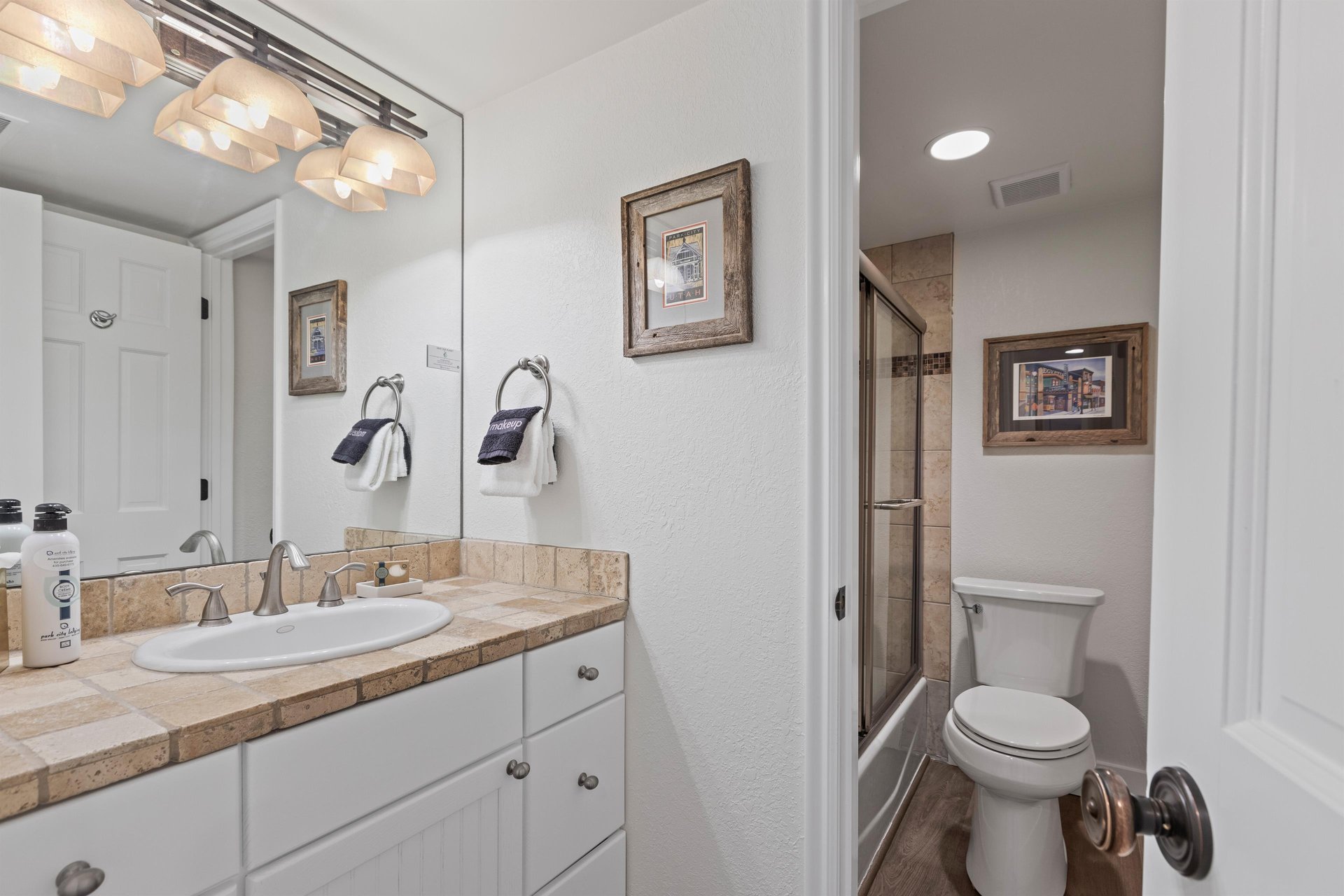 The shared bathroom offers a single sink vanity and bathtub and shower combination.