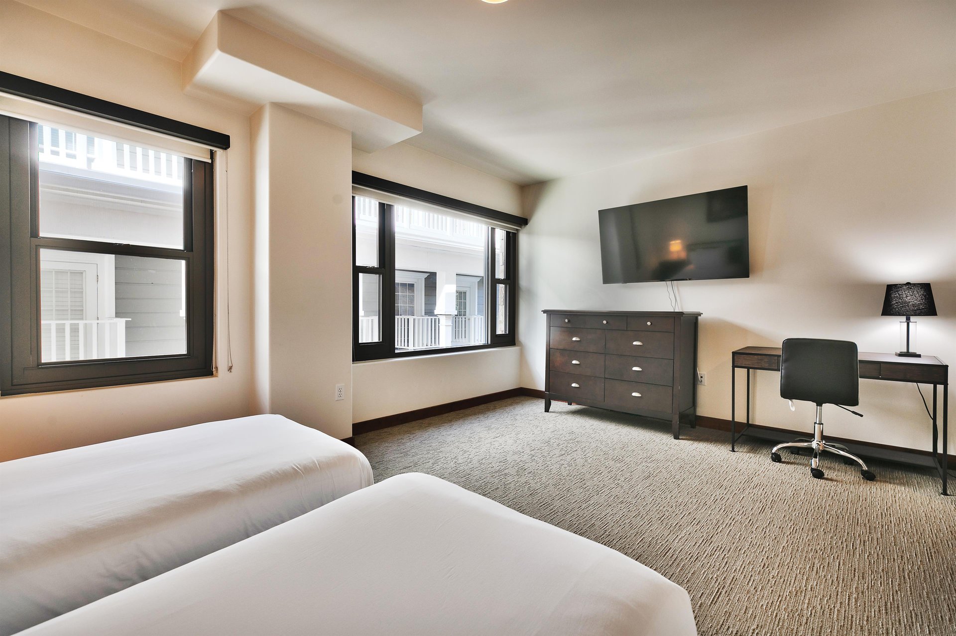 Guest bedroom with wall mounted flat screen TV and dedicated work or study desk