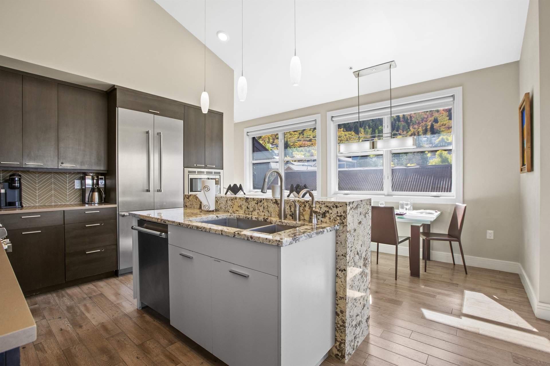 Open concept kitchen with waterfall island and stainless steel appliances.