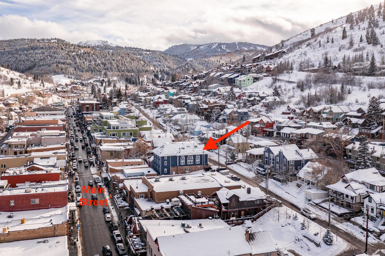 Blue Church Lodge exterior with the snowy Historic Main Street in Park City and Park City Mountain behind.