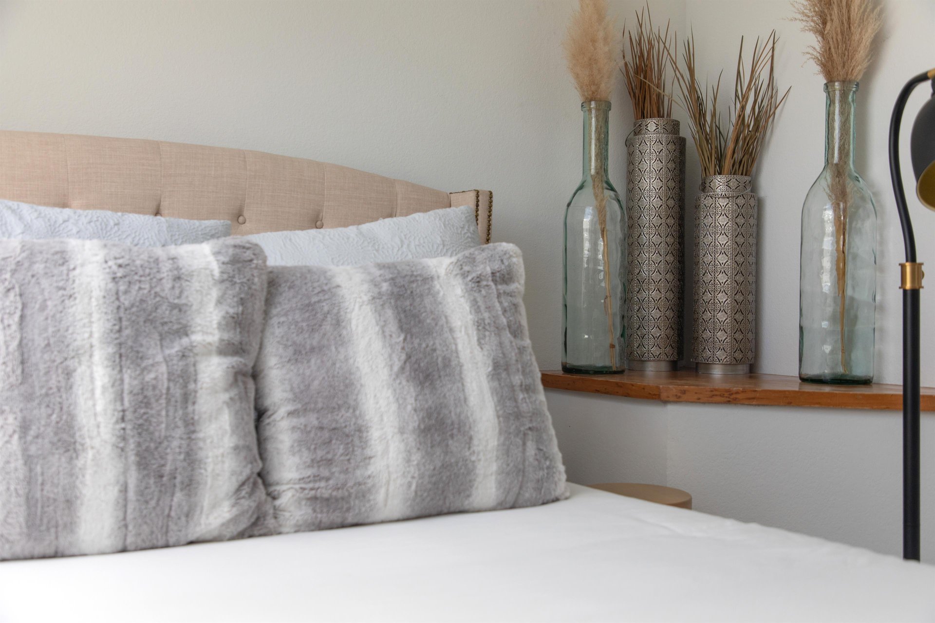 The queen size bed with stylish decor and throw pillows.