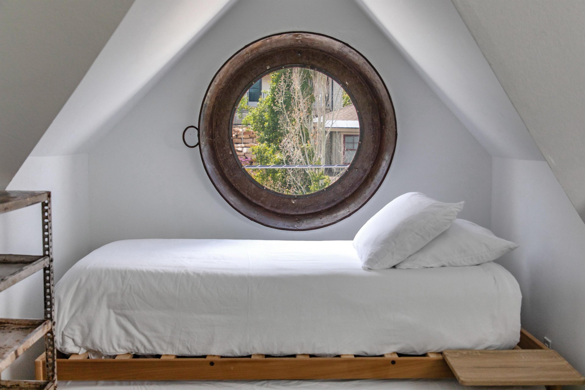 The twin bed with twin trundle and a round window overlooking town.