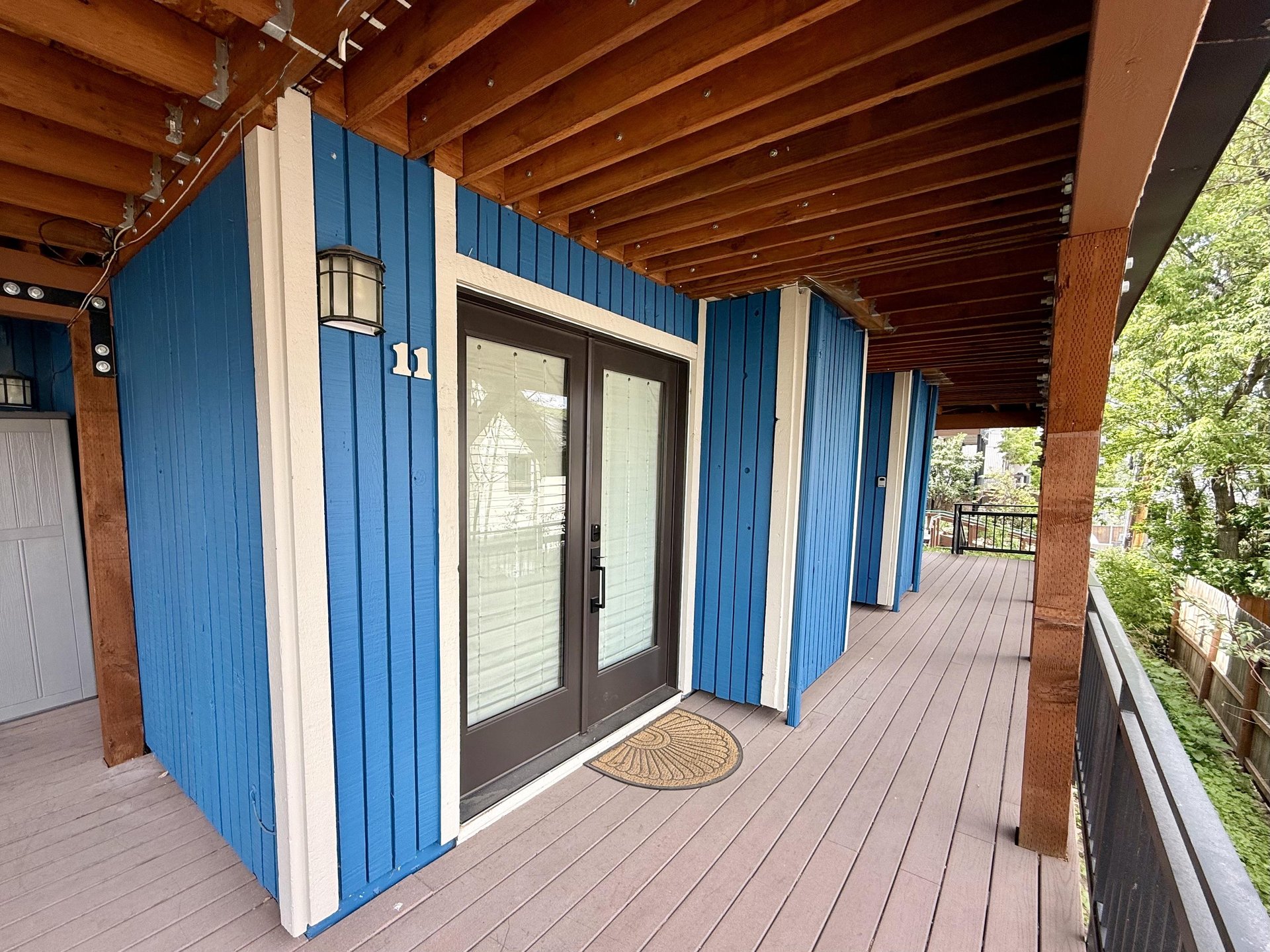 The vibrant blue exterior and welcoming doubledoor entry of Woodside 11.