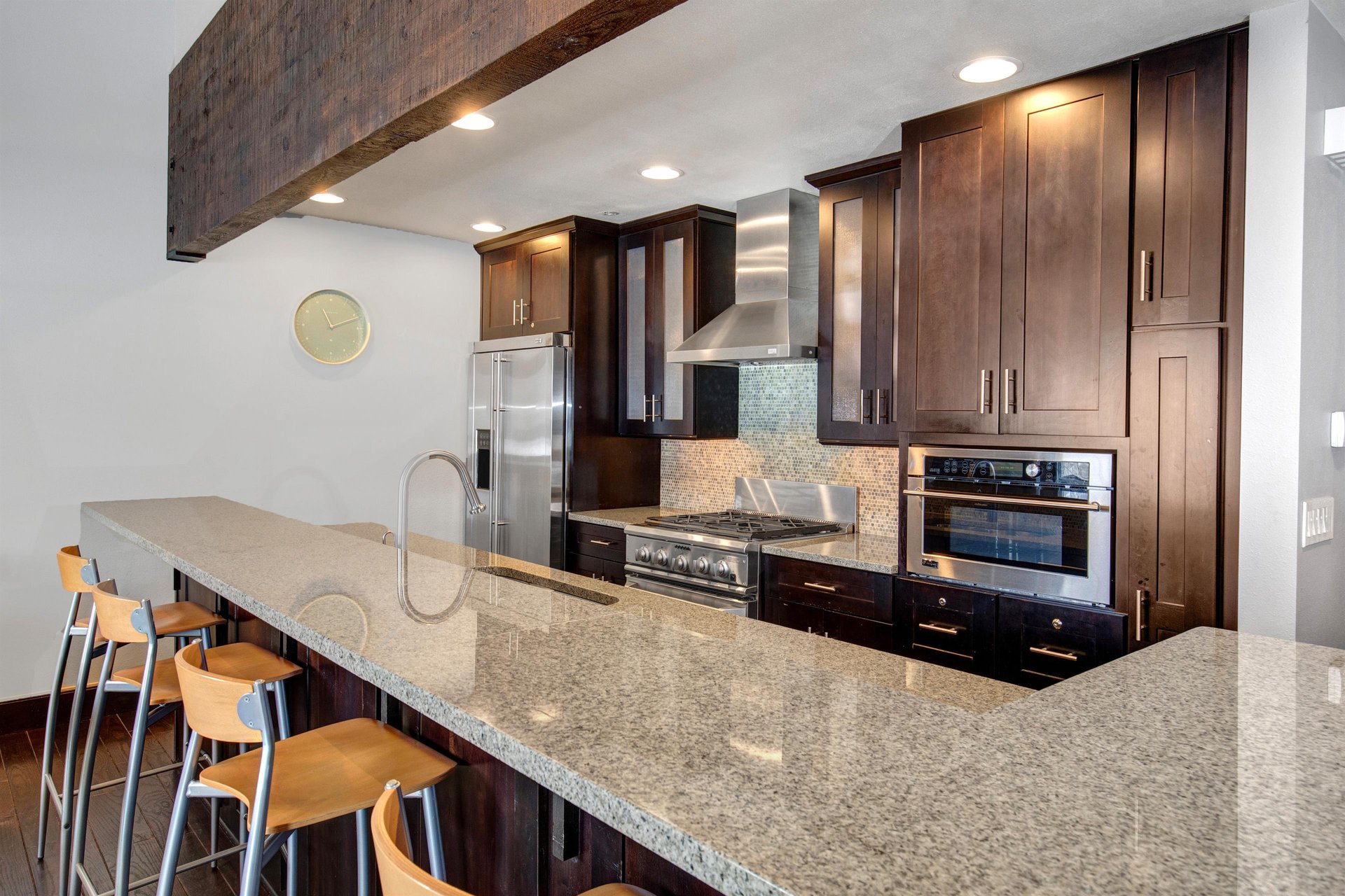 The wellequipped kitchen has dark wood cabinets, stainless steel appliances and island.