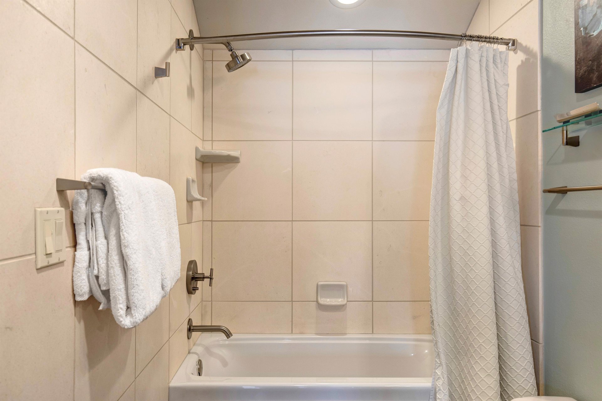 The bathroom with a combination shower and bathtub.