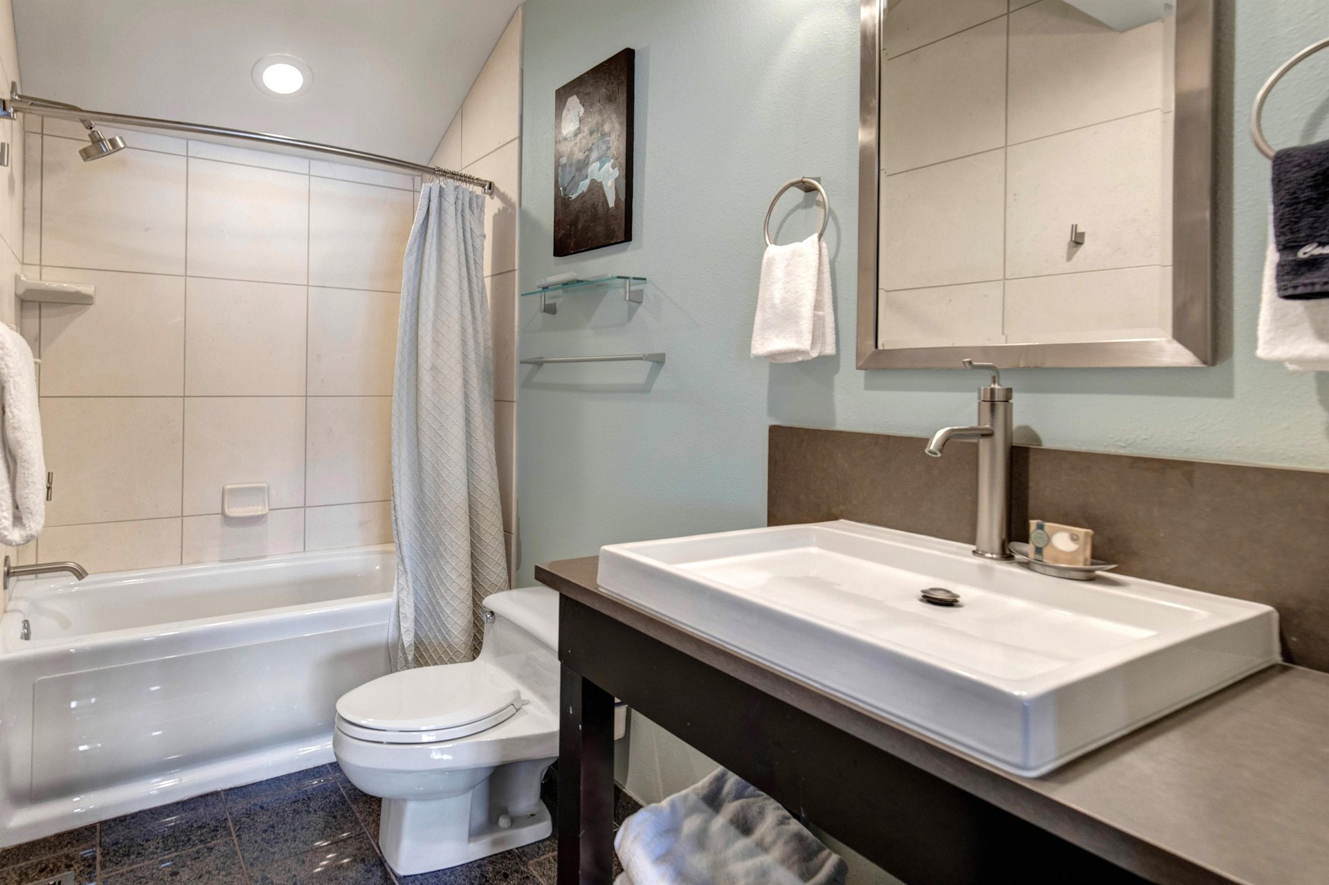 The bathroom with a single sink vanity.
