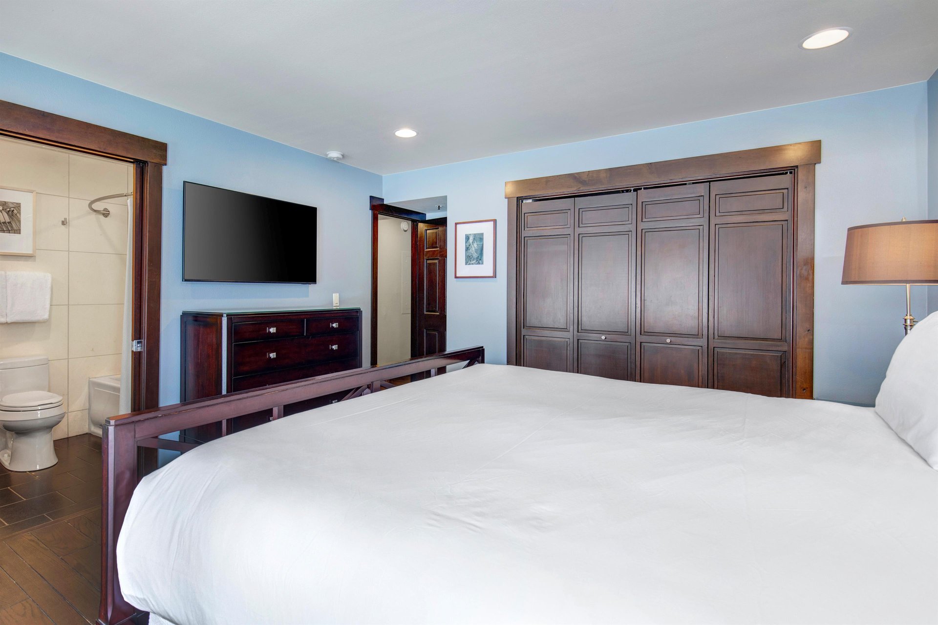 The main suite with a king size bed, comfortable furnishings, and flat screen TV.