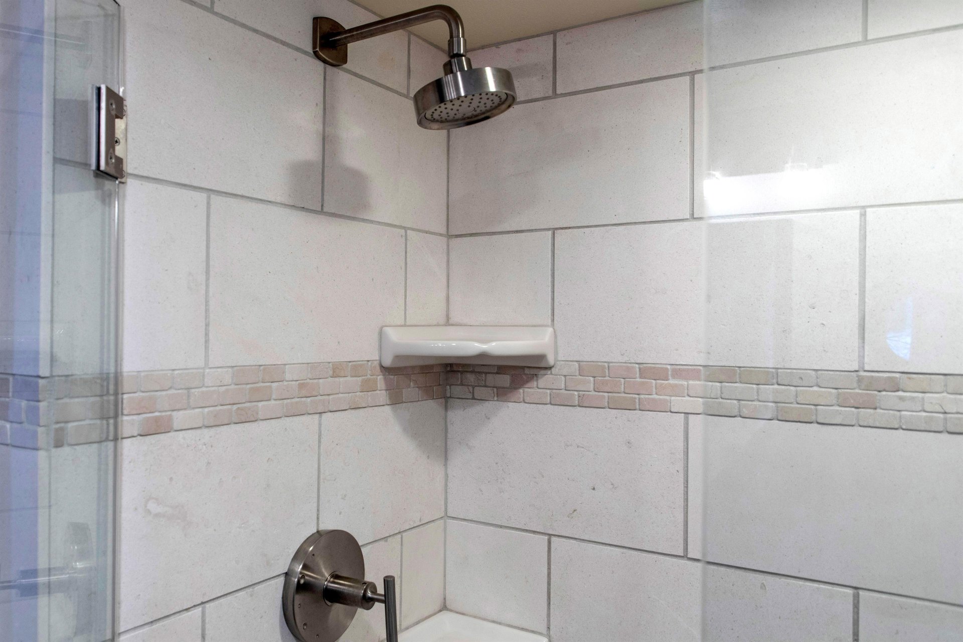 The bathroom with a walkin tiled shower.